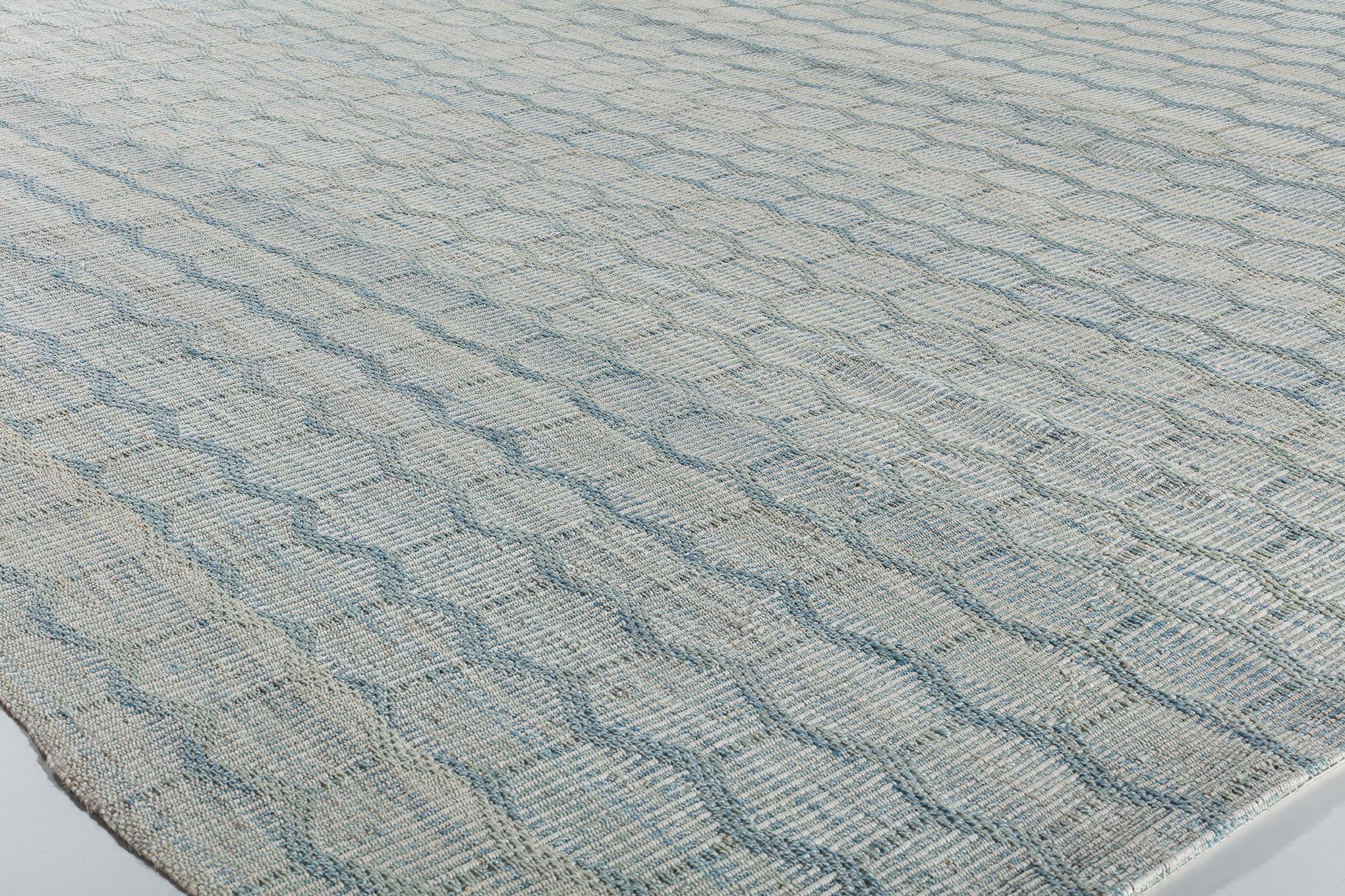 Questo tappeto Charmo a trama piatta è realizzato con lana filata a mano e tinture naturali. Si ispira agli antichi kilim originari della regione curda dell'Iran. NASIRI continua la sua ricca tradizione nella produzione di tappeti applicando le