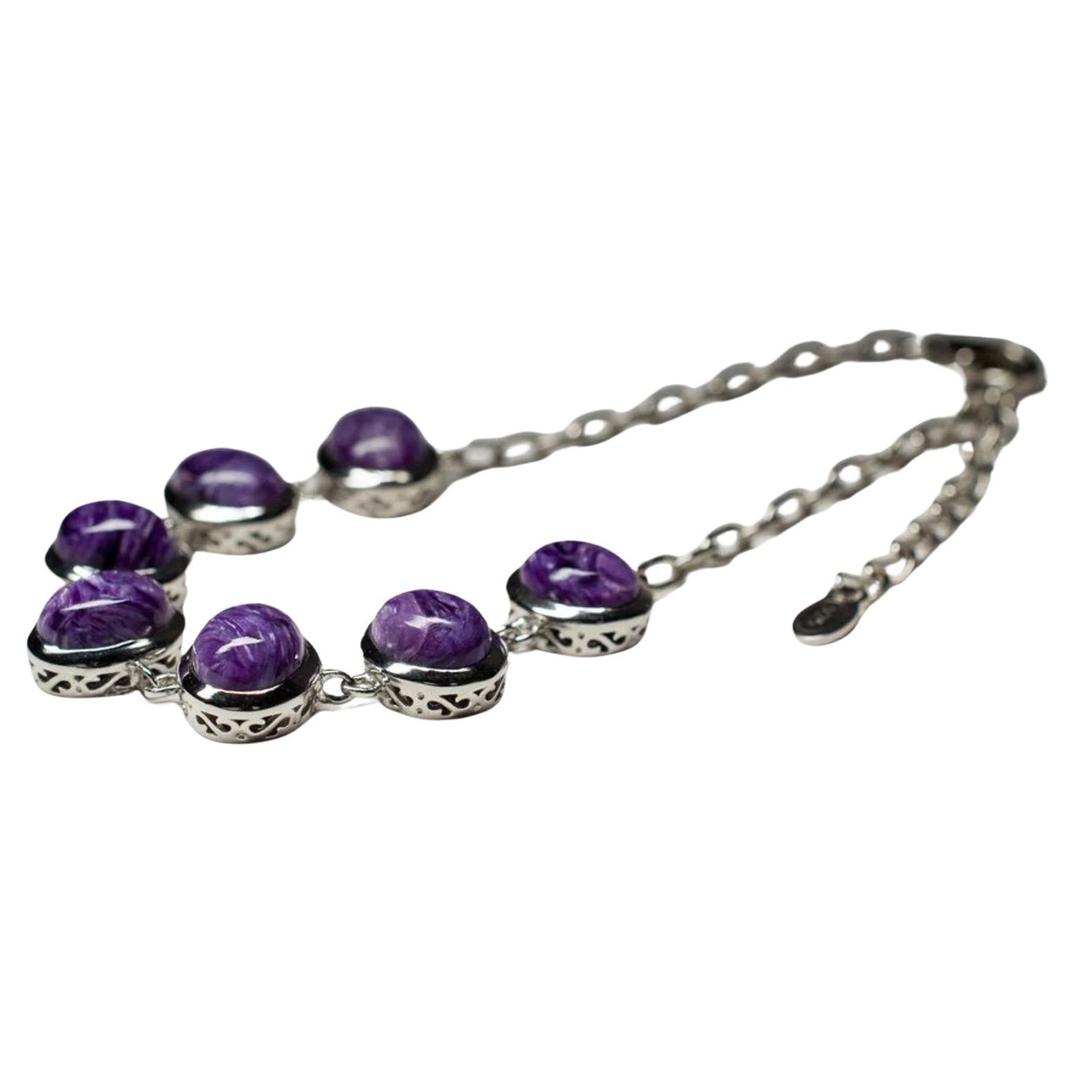 Elegant Adjustable Silver Bracelet with Seven Charoite Cabochon Stones
Featuring seven high-quality cabochon-cut Charoite stones, each with its unique, mesmerizing purple hues, this bracelet is a true statement piece. The stones are carefully set in