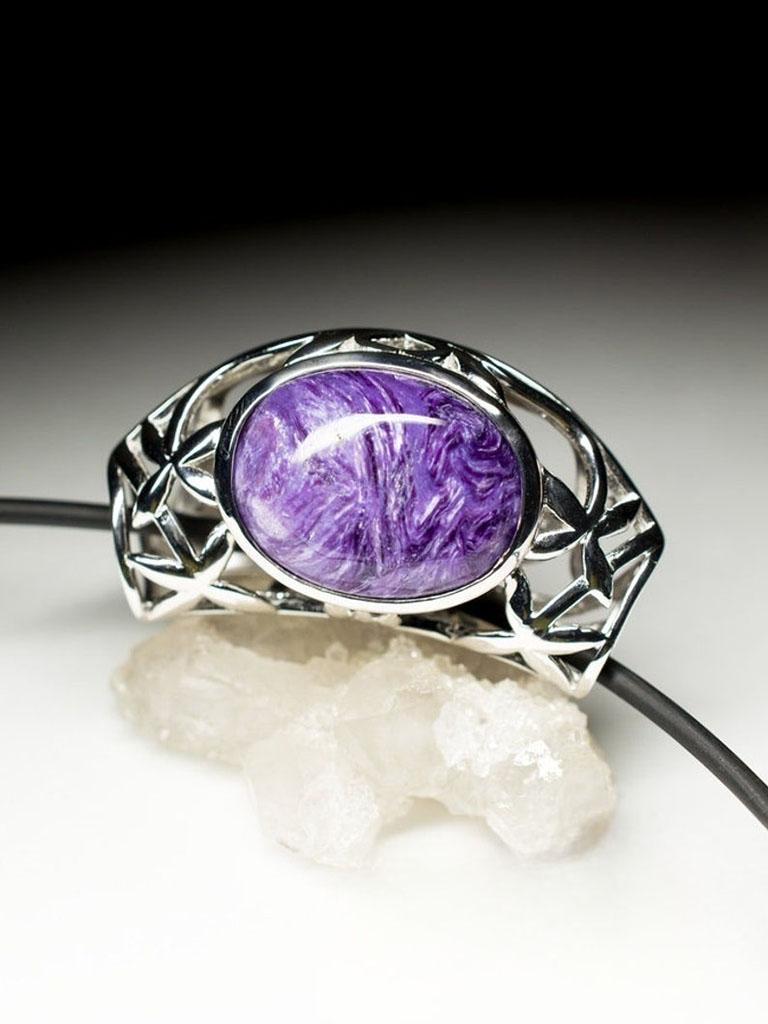 Un ciondolo scultoreo in argento con una charoite naturale dal colore e dalla consistenza sorprendenti. La gemma, che misura 0,2 × 0,59 × 0,79 pollici (5 × 15 × 20 mm), mostra i caratteristici motivi vorticosi della charoite in vivaci tonalità di