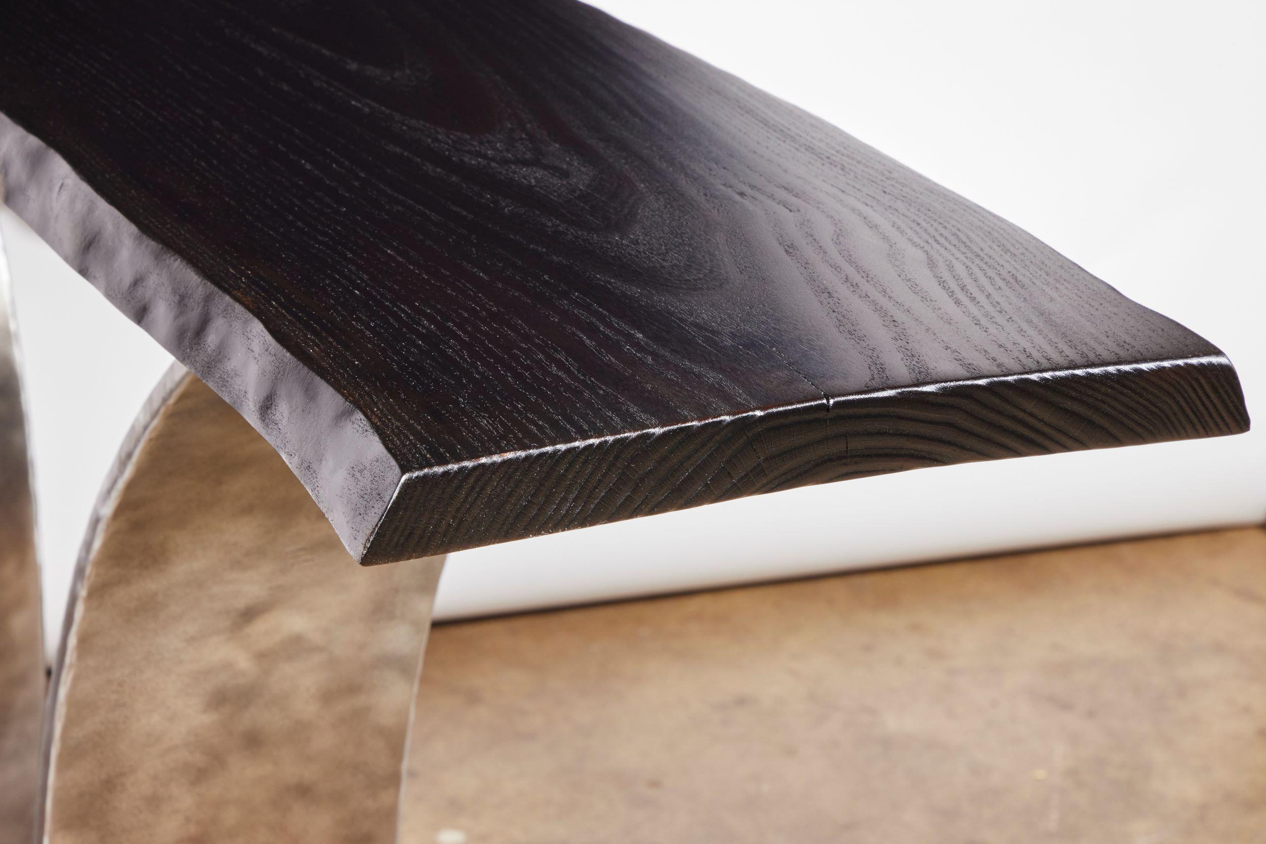Cette élégante table console de Carlo Stenta est une table d'entrée sculpturale qui allie le moderne-industriel à l'organique. La console Tina de Recovery Furniture, en acier teinté, présente une dalle d'eucalyptus à bord vif carbonisé reposant sur
