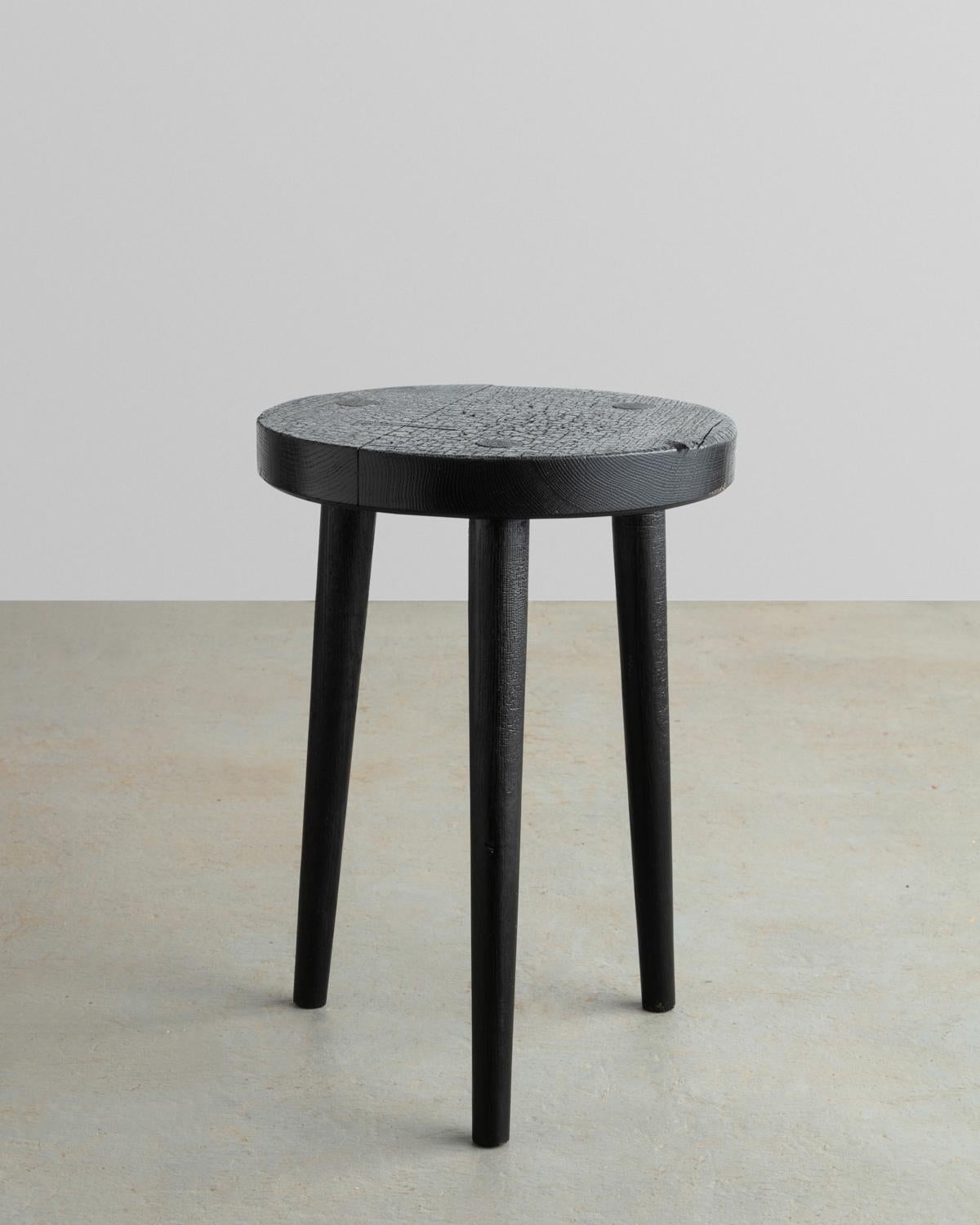 Designed and constructed from solid Oak this three-legged stool features hand chiseled solid Oak butterfly joinery to solidify its top surface. Staying true to traditional techniques the stool is charred with a blowtorch to preserve its authentic