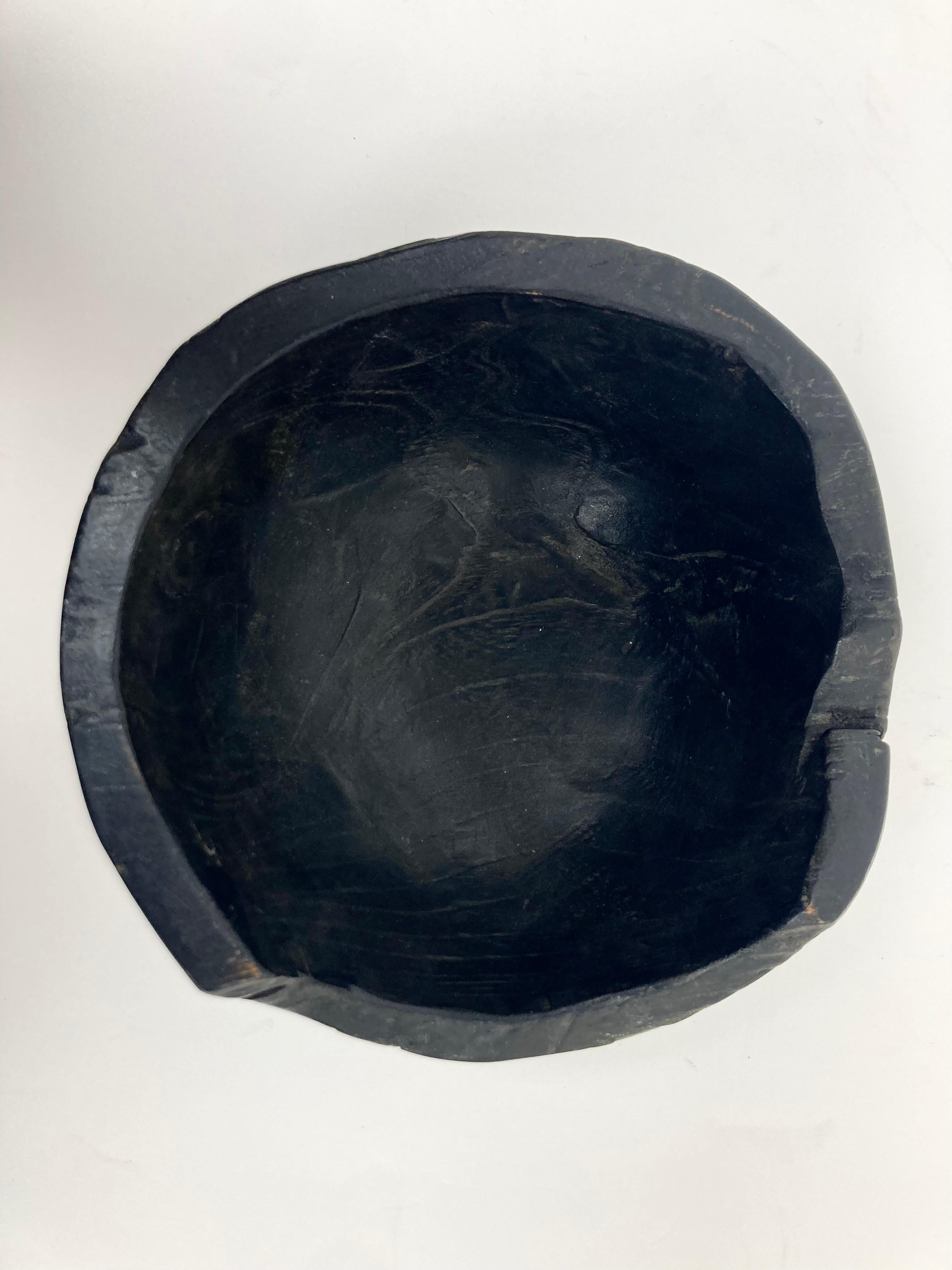 Un cuenco de madera carbonizada con buen peso, grosor y fino pulido satinado. El Cuenco presenta pérdidas intencionadas en la parte superior y en el borde y muestra un veteado profundo tanto en el interior como en el exterior que resulta