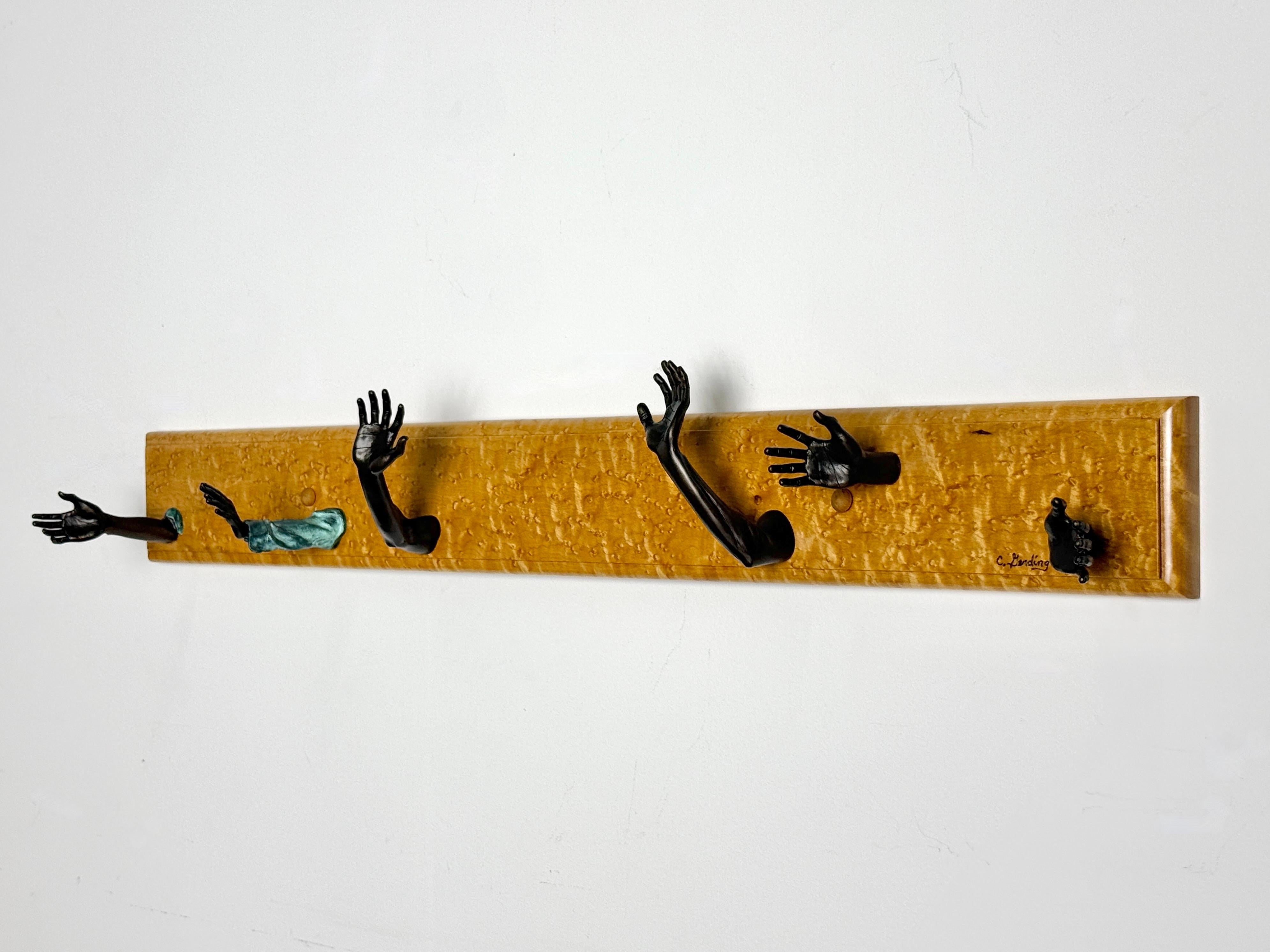 Wall mounted coat rack by Traverse City, Michigan artist Chas Gerding
USA 1989

Rectangular mount in Birdseye maple with six unique bronze hands that serve as hooks
Signed to one hand, lower right and artist card to back

30 inch width
4.5 inch