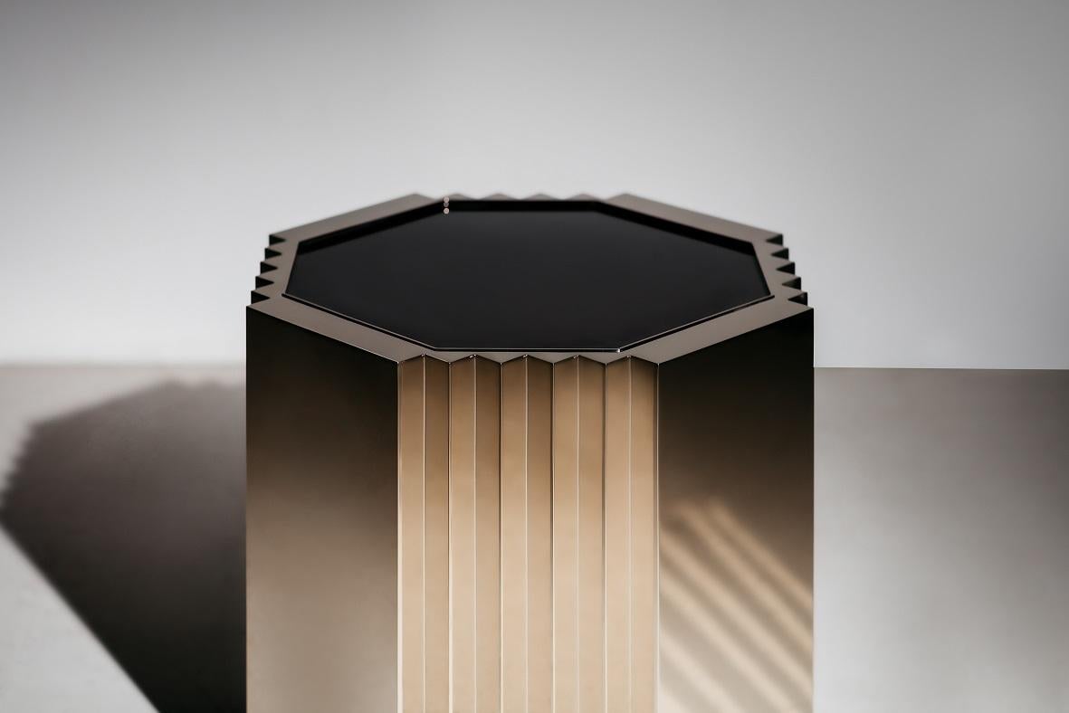 A hexagonal side table with four zigzag sides and four flat panels, all in a high shine, champagne gold metal finish. The high gloss lacquered timber top lies slightly inset to the metal edges. A table
built to create dramatic Industrial