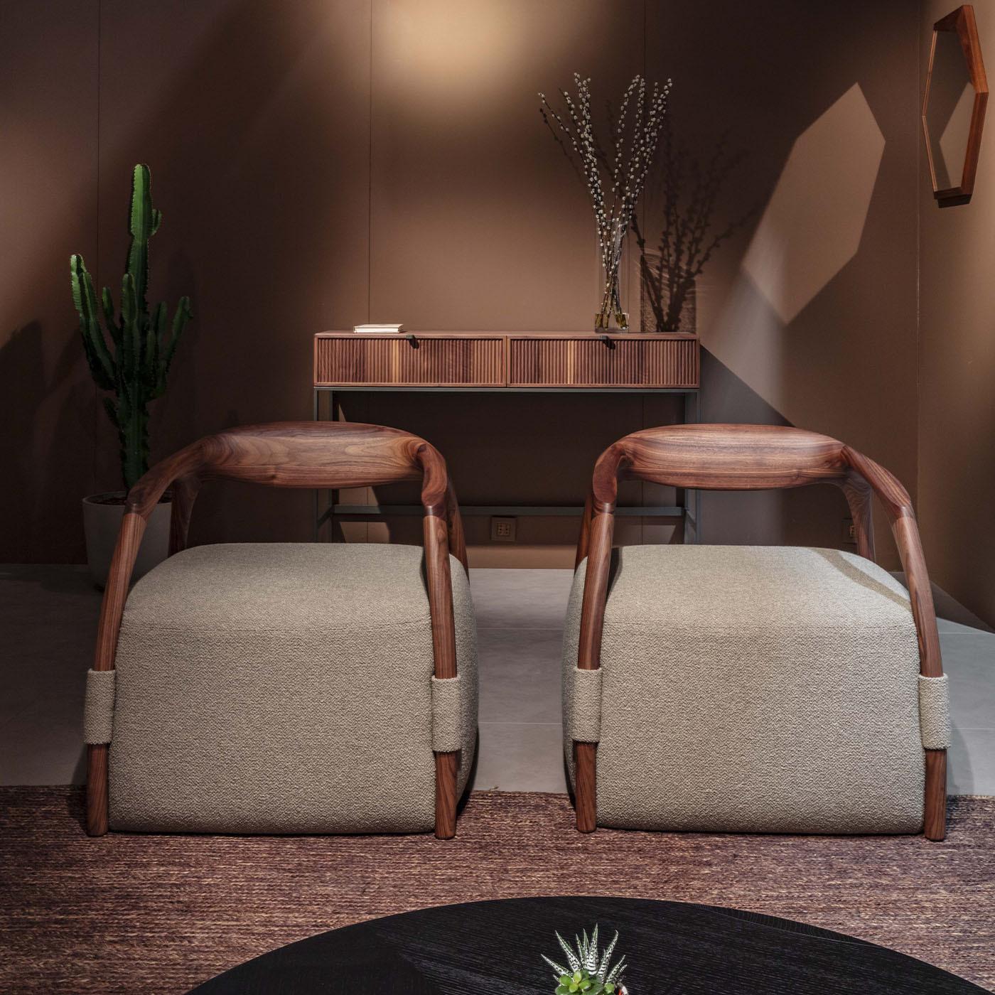 Distinguished by its robust Canaletto walnut wood frame and sumptuous brown fabric upholstery, this armchair stands as an icon of original design and artisanal excellence. Its slender armrests and cut-outs lend the chair an airy lightness, elevating