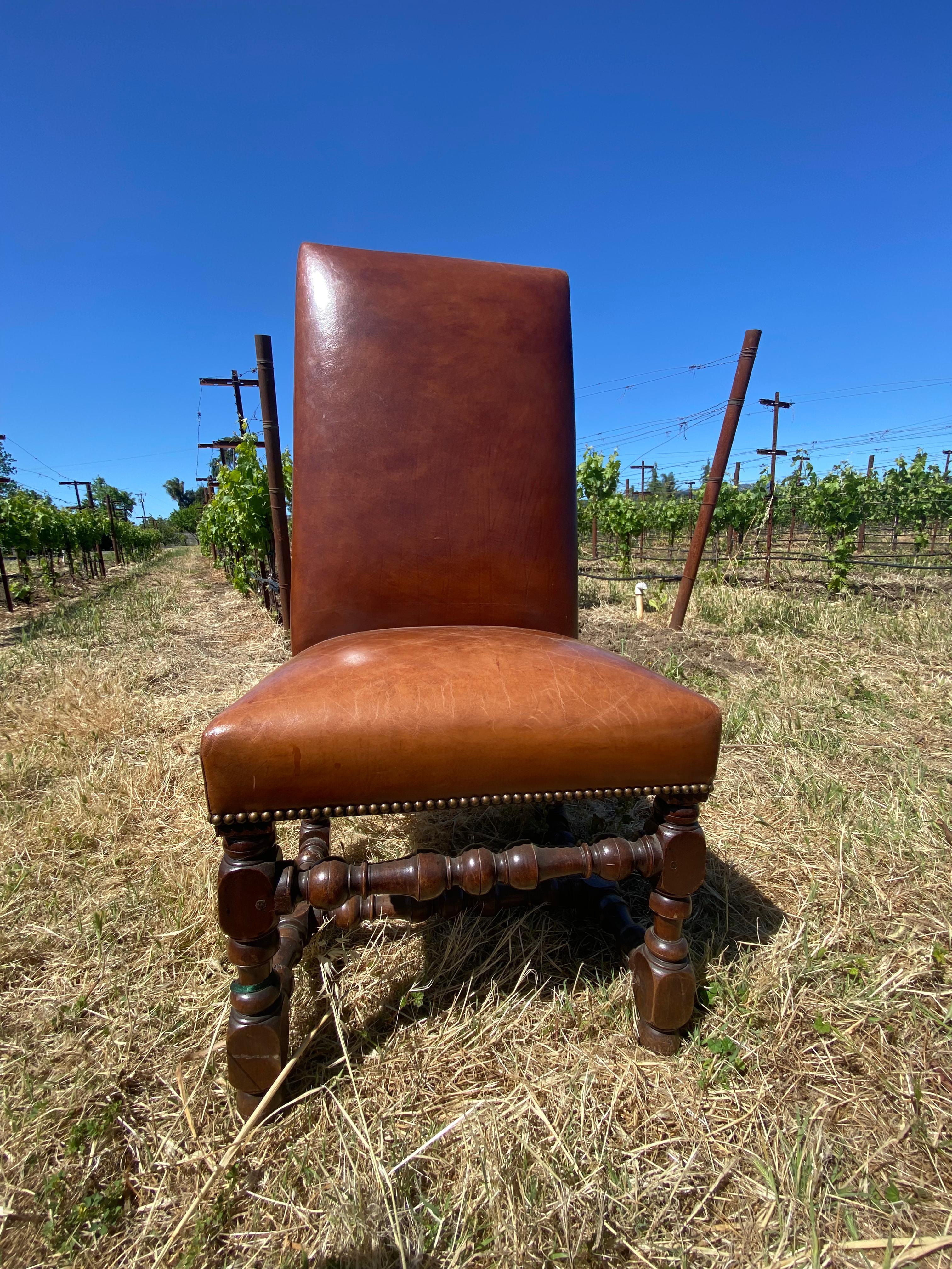 19th century French walnut high back chair. Turned and dowelled legs with deep antique patina. Reupholstered with a dark tan leather and finished with nailhead trim.