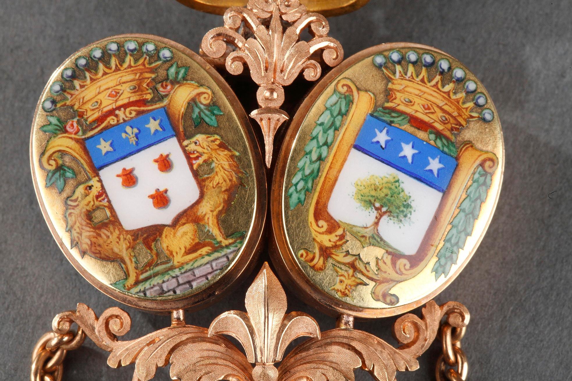 Chatelaine with belt hook in intricately sculpted, matte, pink gold. The piece is topped with a crown featuring pearls and semi-precious stones. Two coats of arms in multicolored enamel are set on gold under the crown, and under the coats of arms is