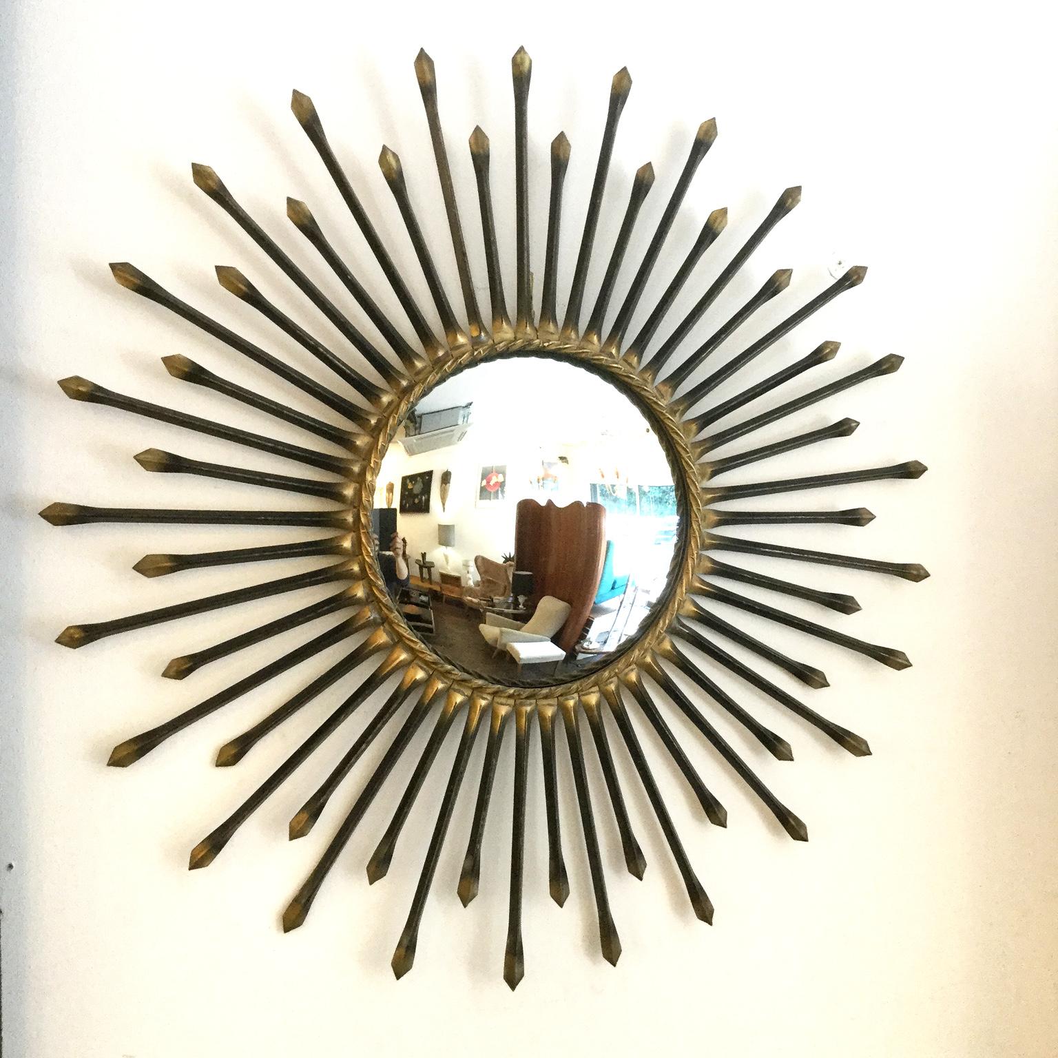 Large sunburst mirror or (witch mirror) manufactured by Chaty Vallauris based in Provence in France.
Metal and gilded frame with an original convex mirror.