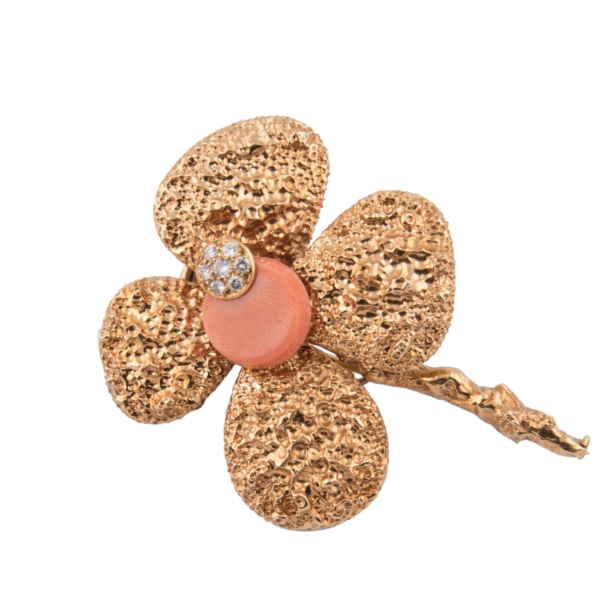 A flower shaped brooch by Chaumet Paris, with textured 18k yellow gold stem and petals, the heart of the flower set with a round disc of pink coral and a smaller disc set with diamonds
Signed Chaumet Paris, maker's mark, French hallmarks
1960s
In