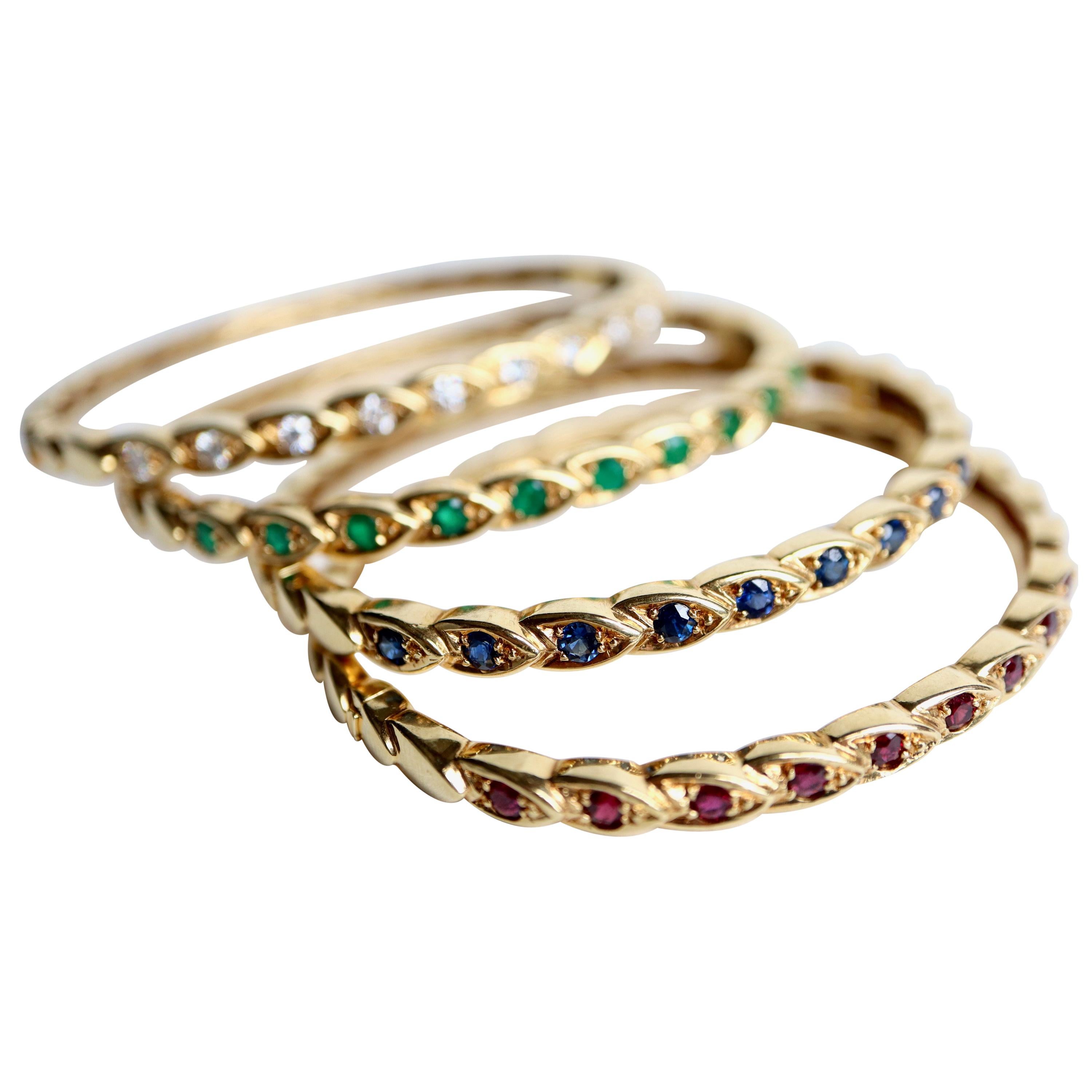 CHAUMET 4 Rigid bracelets in yellow gold and emerald, sapphire, ruby ​​and diamond precious stones. The bracelets are composed of ears of yellow gold among which a dozen ears crimp precious stones on the top of the bracelets. The bracelets are oval
