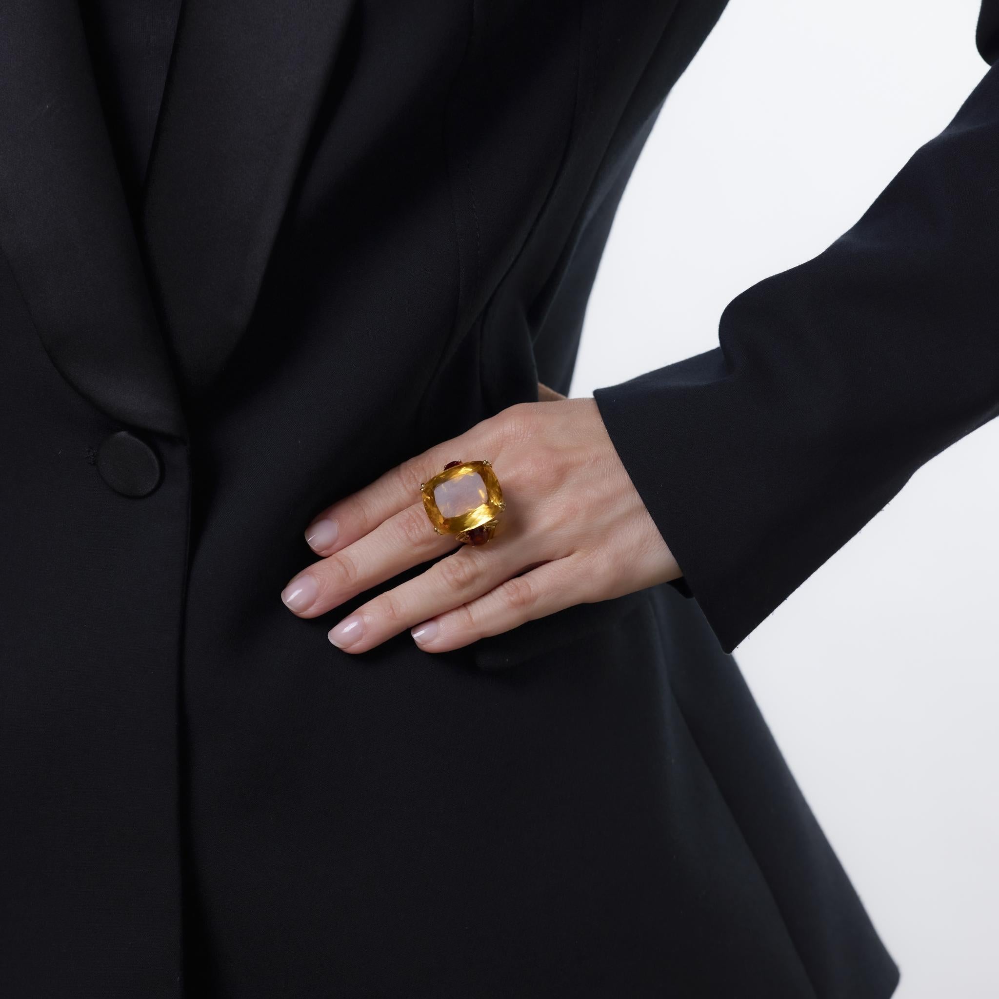 Cette bague vintage audacieuse de Chaumet, réalisée en or jaune 18 carats, met en valeur une citrine de 45,50 carats de taille coussin, flanquée de deux citrines de Madère de taille ovale d'une valeur totale d'environ 3,15 carats. D'un design