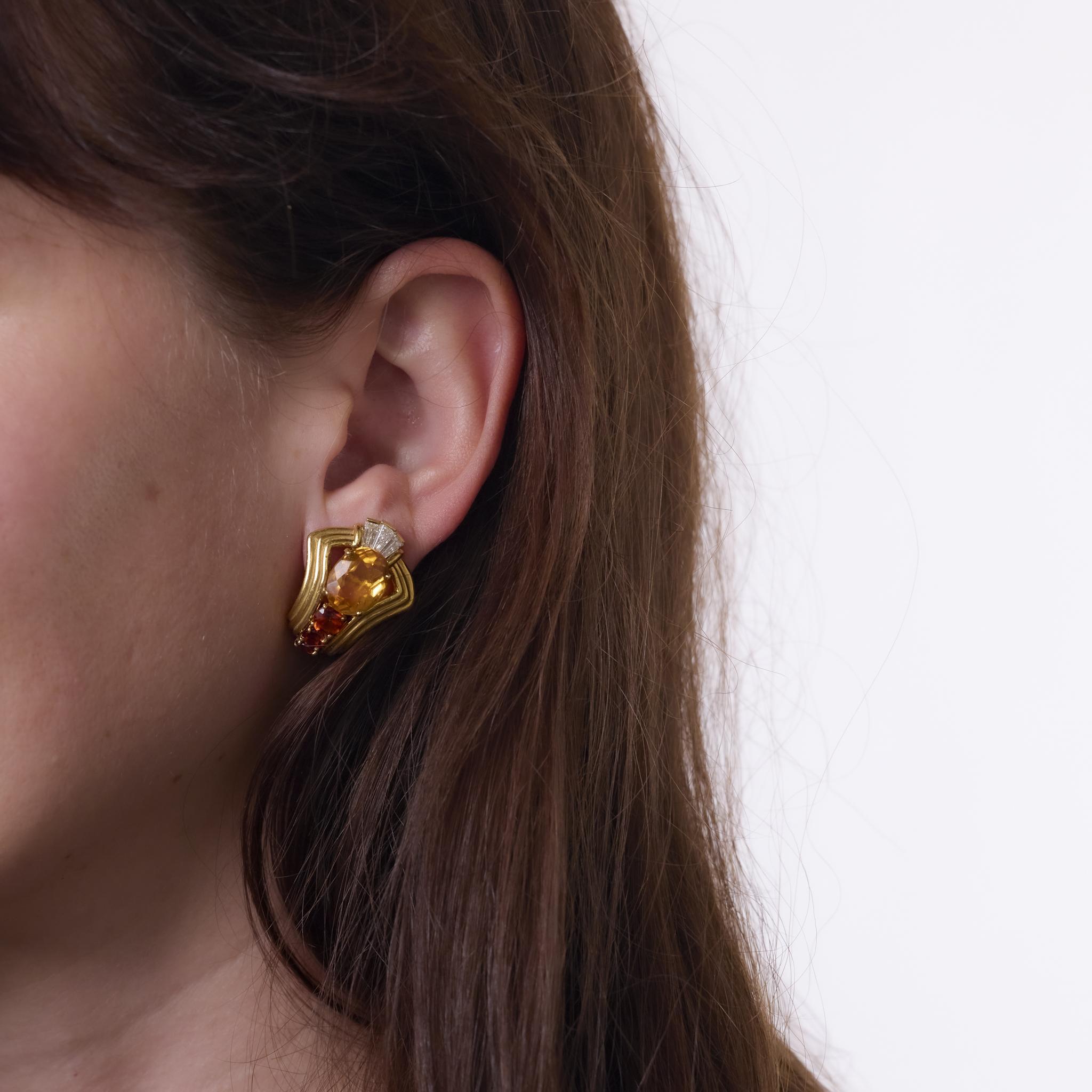 Ces boucles d'oreilles vintage Chaumet des années 1970 sont réalisées en or jaune 18 carats et présentent une étonnante combinaison de pierres précieuses. Deux citrines de taille ovale totalisant environ 7,20 carats sont rehaussées par six citrines