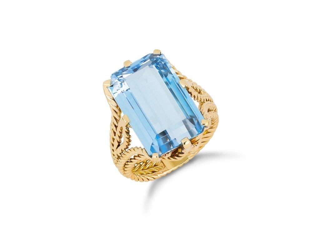 Chaumet aquamarine ring. Set with an octagonal step cut natural aquamarine in an open back claw setting with an approximate weight of 7.40 carats, to an impressive solitaire design featuring twisted gold metalwork, stylised claws, open backholing