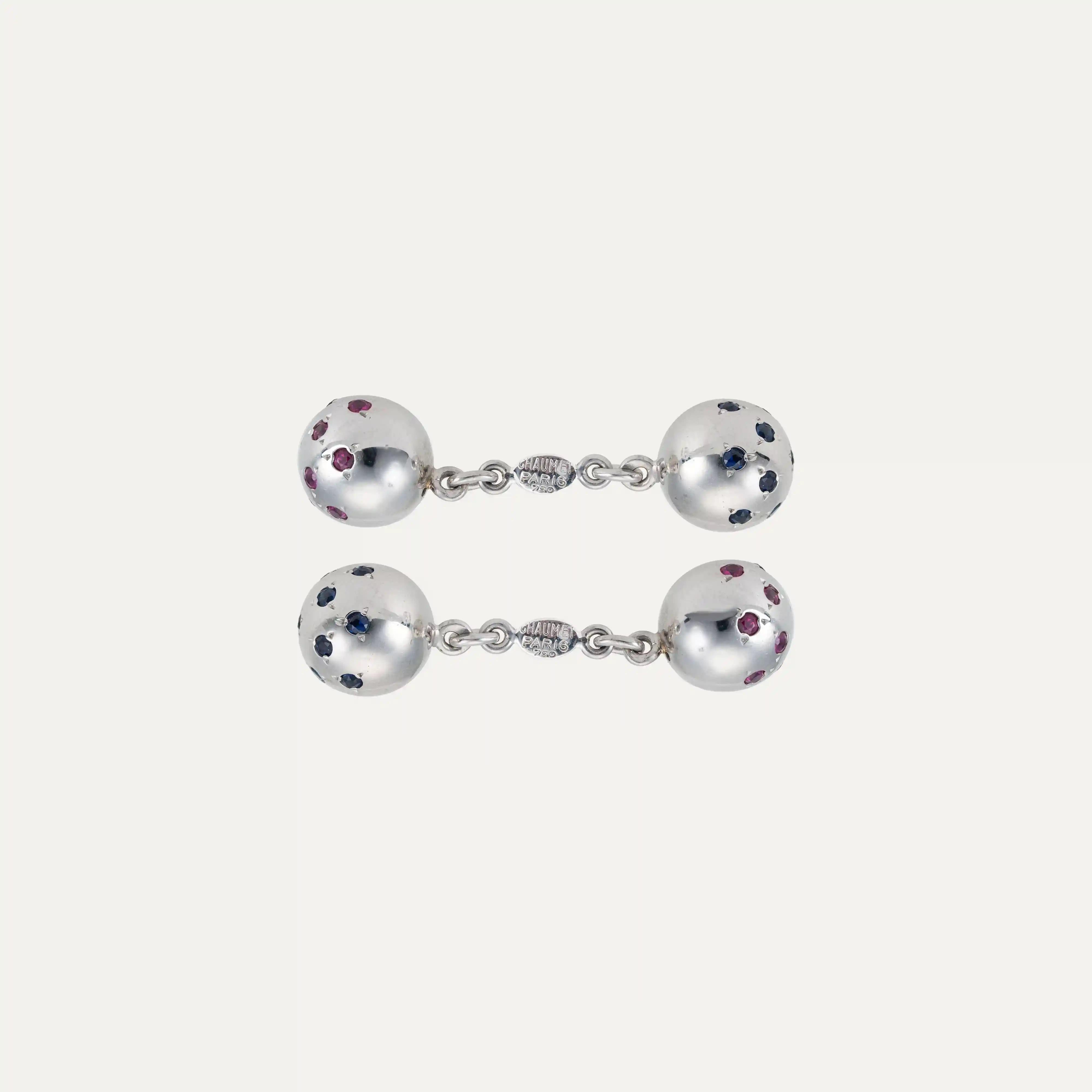  Gemelli Chaumet in oro bianco 18kt - 750‰, con quattro sfere in oro bianco. Due delle sfere sono incastonate con 26 zaffiri blu, mentre le altre due sono incastonate con 26 rubini, creando un contrasto elegante e distintivo. Firmato 