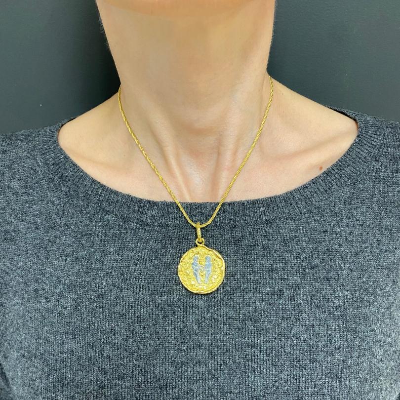 

DESIGNER: Chaumet, Parigi
CIRCA: anni '80
MATERIALI: Oro giallo e bianco 18 carati
PESO: 25,1 grammi 
MISURE: Diametro del ciondolo - 1 1/8