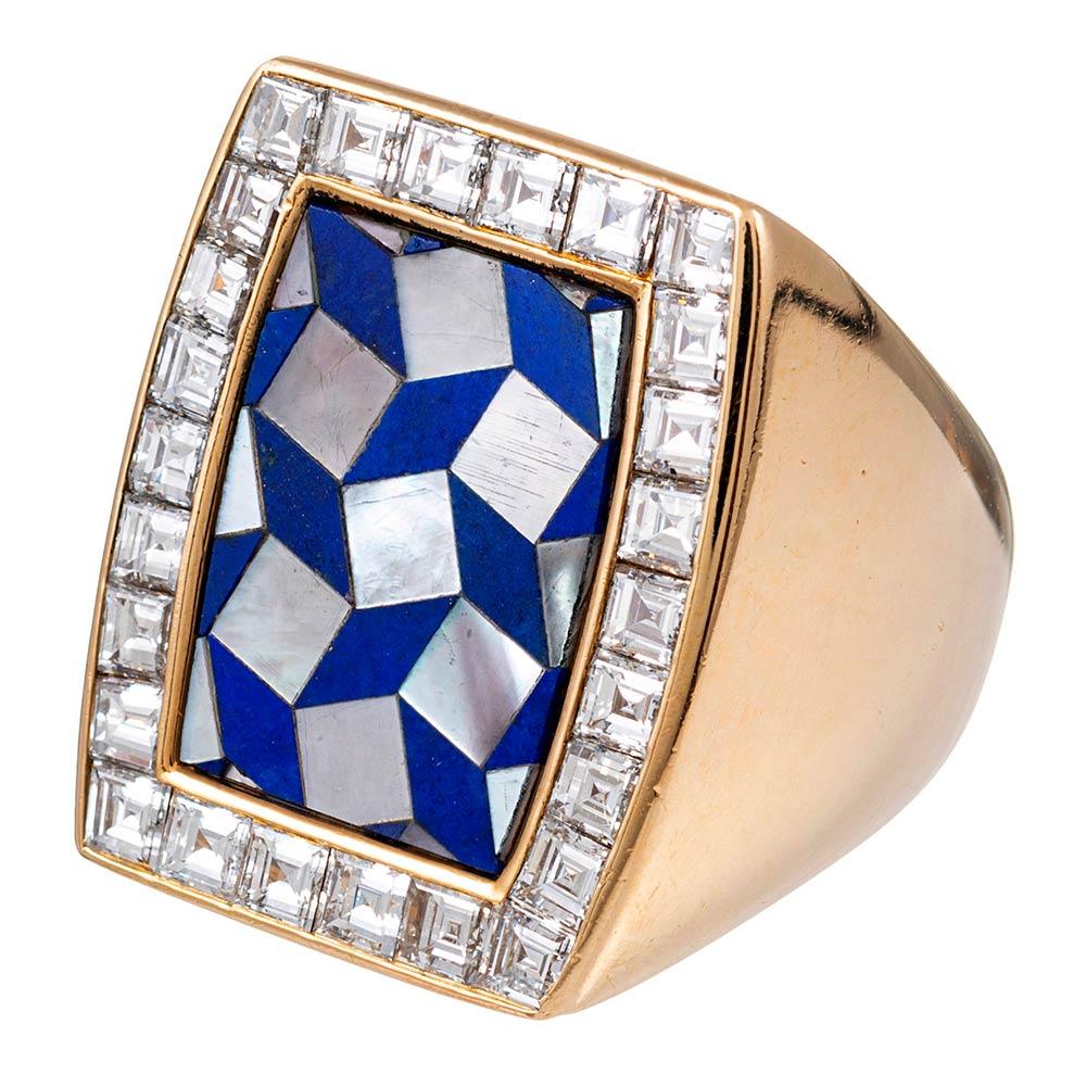 This bold ring is suitable for a lady or a gentleman. The top is an intricate mosaic of lapis and mother of pearl, with a single frame of square cut white diamonds. The diamonds weigh approximately 4 carats in total. The ring is made of 18 karat