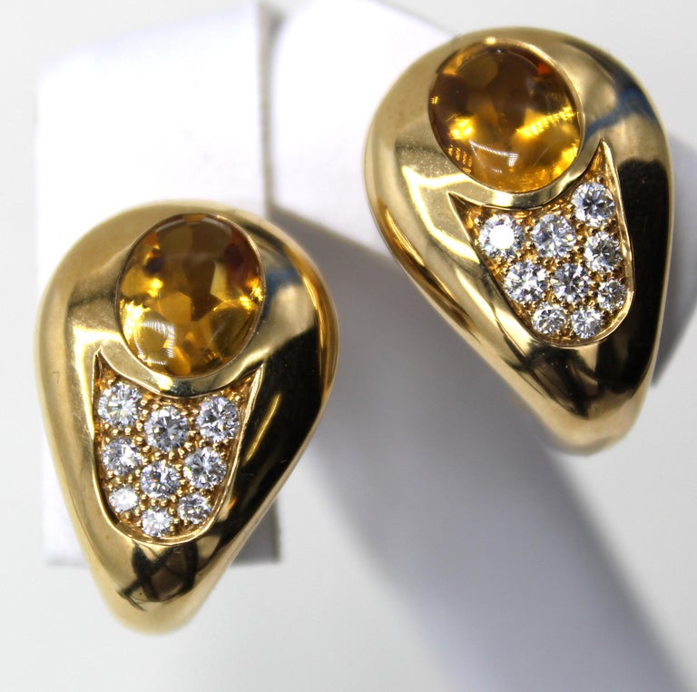 Beautifully designed and masterfully handcrafted by the renown French jeweler Chaumet Paris these charming 18 Karat yellow gold ear clips are each set with one oval buff-cut Citrine and embellished by 9 bright white and sparkly round brilliant cut