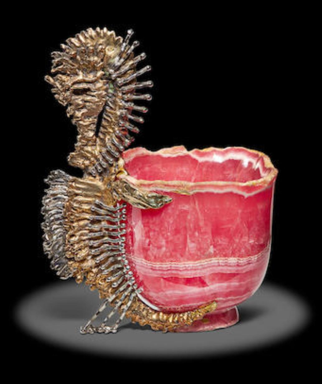 Chaumet Paris, A French Silver-Gilt Seahorse Mounted Rhodochrosite cup

Circa 1980.

An exceptional object

A quadrangular cut cup in rhodochrosite and the handle made of a seahorse in silver and silver gilt naturally chiselled in the