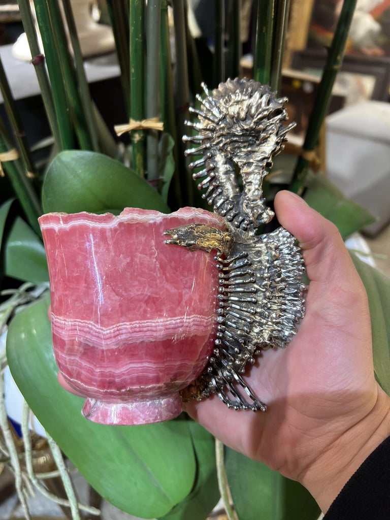 Chaumet Paris, A French Silver-Gilt Seahorse Mounted Rhodochrosite cup

Circa 1980.

An exceptional object

A quadrangular cut cup in rhodochrosite and the handle made of a seahorse in silver and silver gilt naturally chiselled in the brutalist