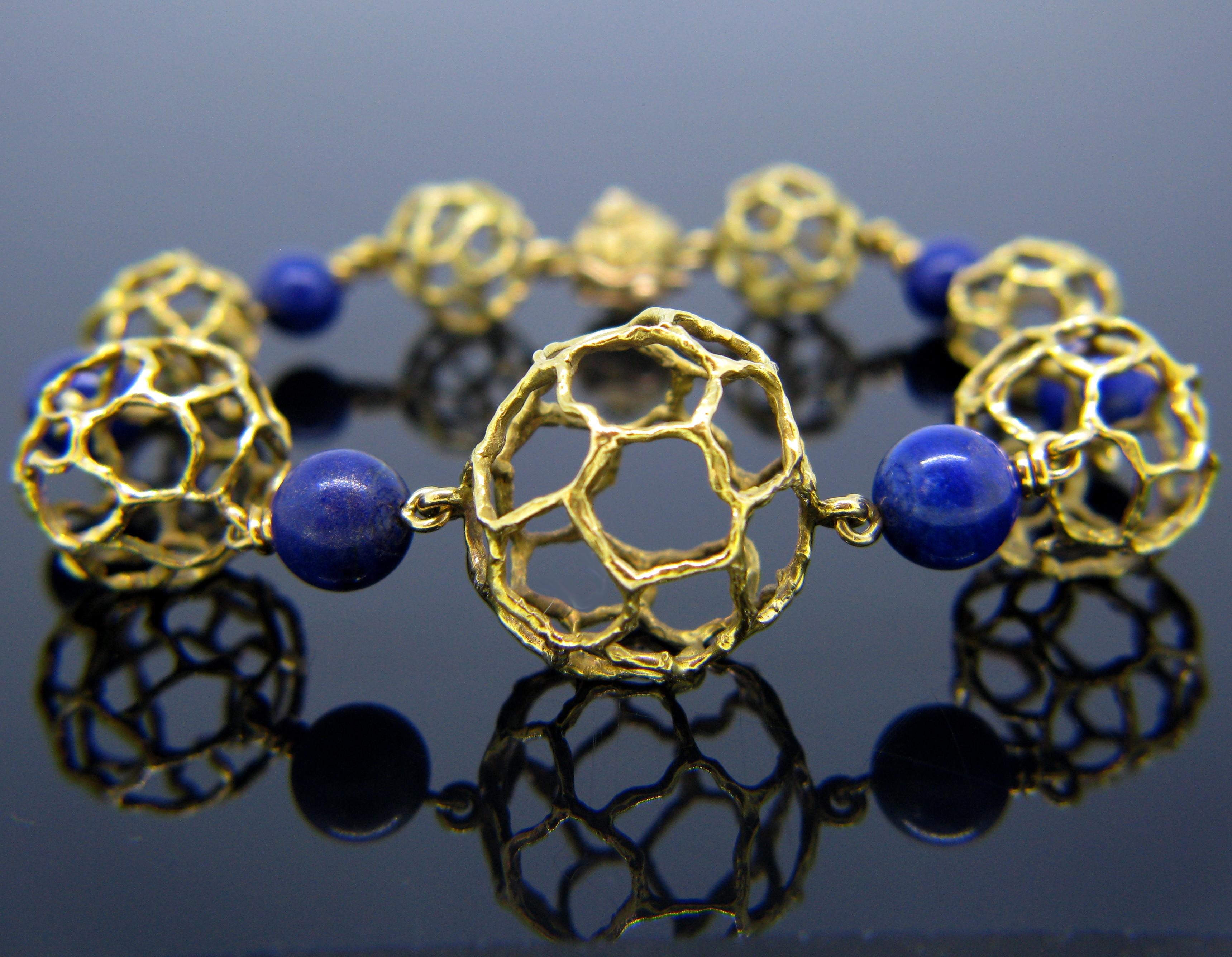 This bracelet is signed Chaumet Paris and is from the 1970s. It consists of six beads of lapis lazuli and seven spheres graduating in size in textured yellow gold. This beautiful bracelet has a very interesting and bold