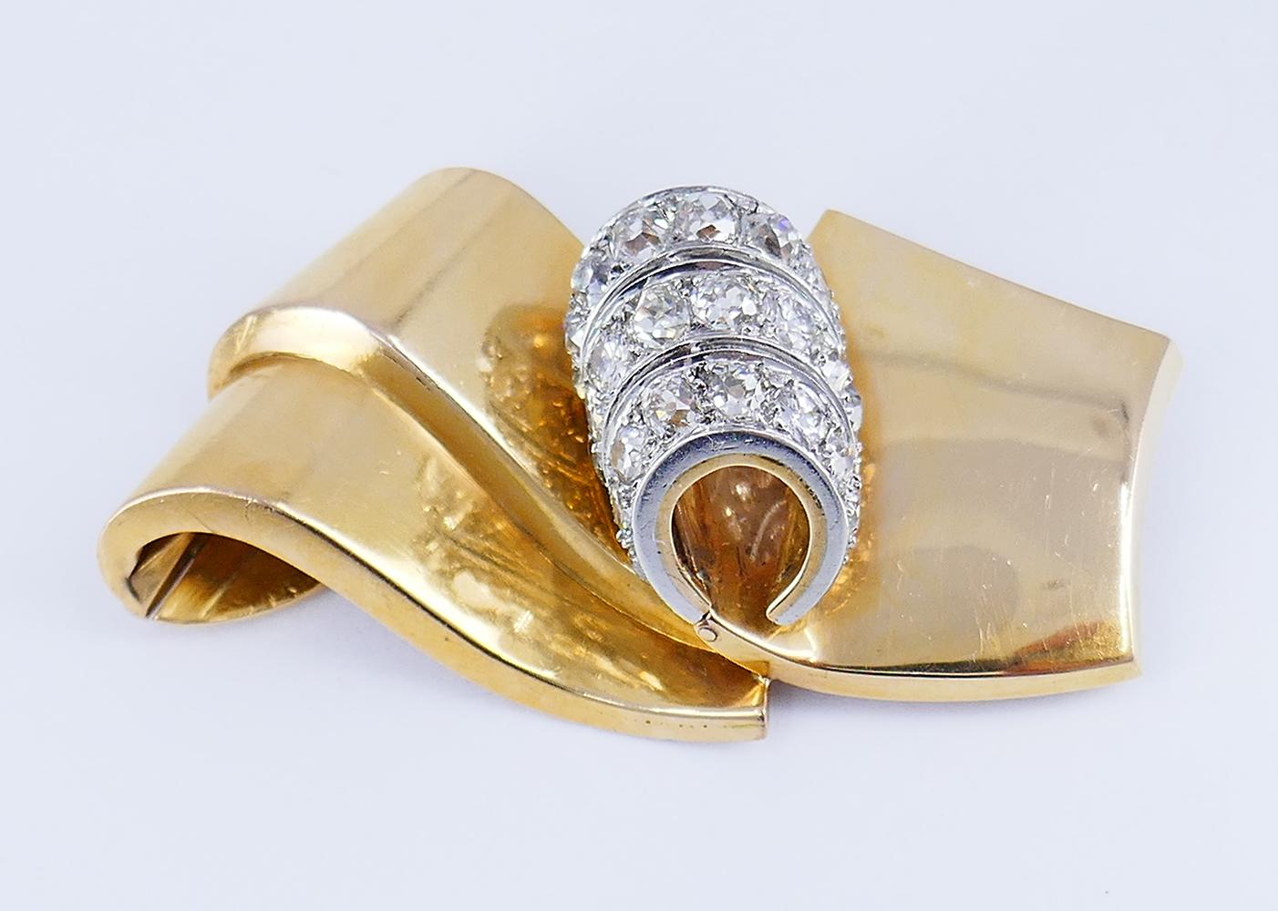         A French chic retro diamond brooch by Chaumet Paris made of 18 karat gold and platinum.

	During the Retro jewelry era, scrolls became one of the most popular design motifs. In this brooch Chaumet perfected the fluidity of the scroll shape.