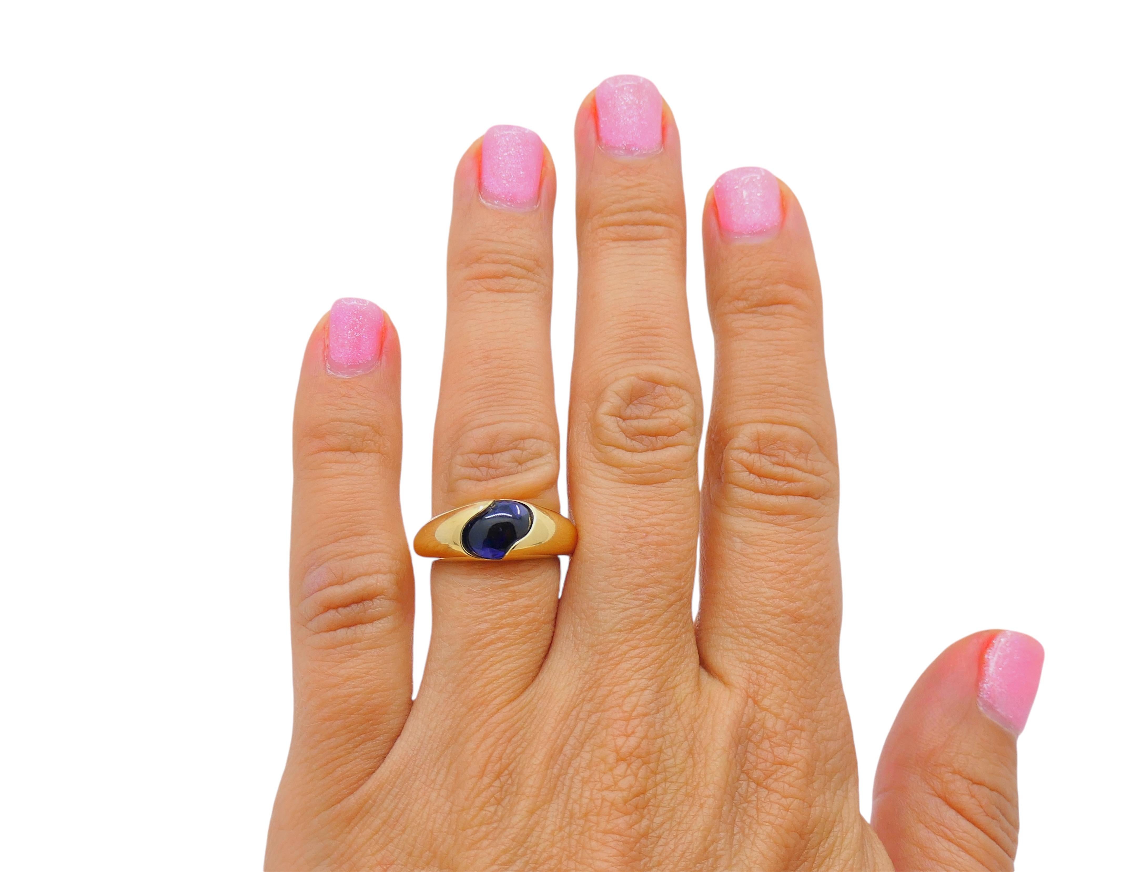 A beautiful Chaumet ring, crafted of 18k gold, featuring blue iolite. The iolite is cabochon cut, flush set in a wavy cutout placed in the center of the ring. The band is
polish gold, and its silky smooth, shiny texture perfectly enhance the