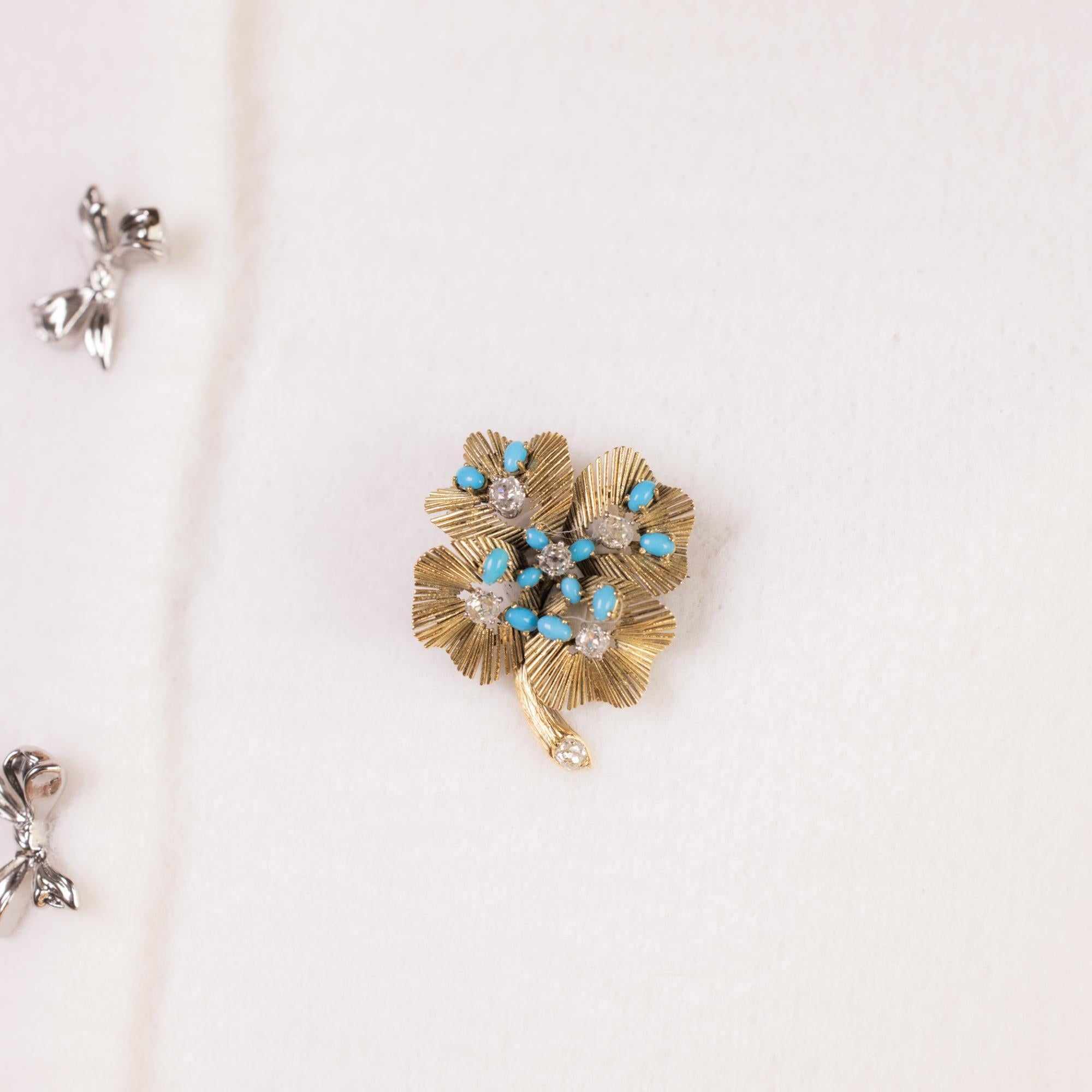 This vintage Chaumet London brooch is a masterpiece of design, featuring 12 cabochon-cut turquoise stones set in rich 18k yellow gold. Six old mine cut diamonds, totaling approximately 1.90 carats, G-H color, SI clarity, add a touch of brilliance to
