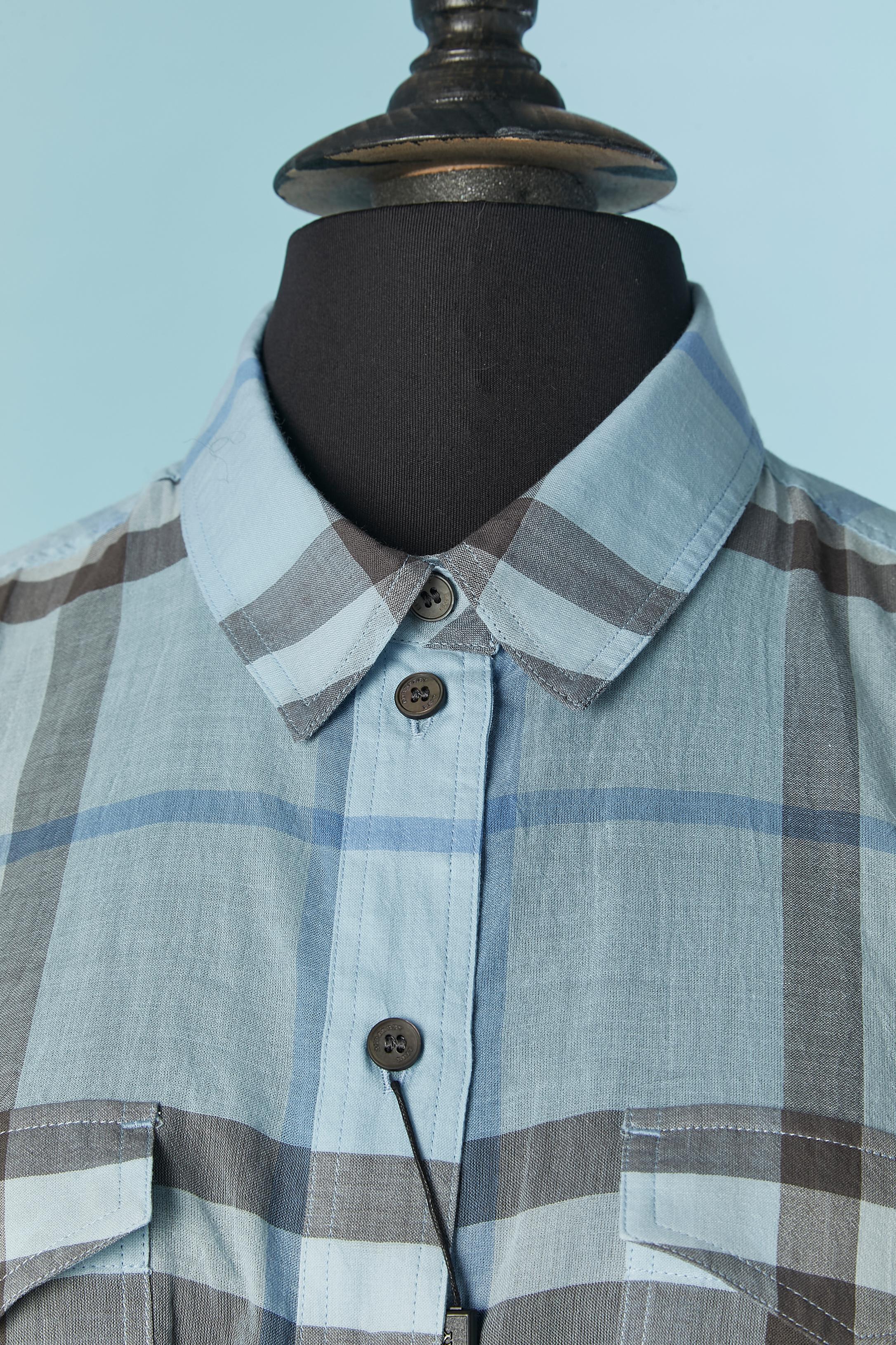 Camicia in cotone con motivo a quadri. Chiusura con bottone e asola con marchio sul centro davanti e sui polsini. 2 bottoni extra in dotazione. 
TAGLIA M 