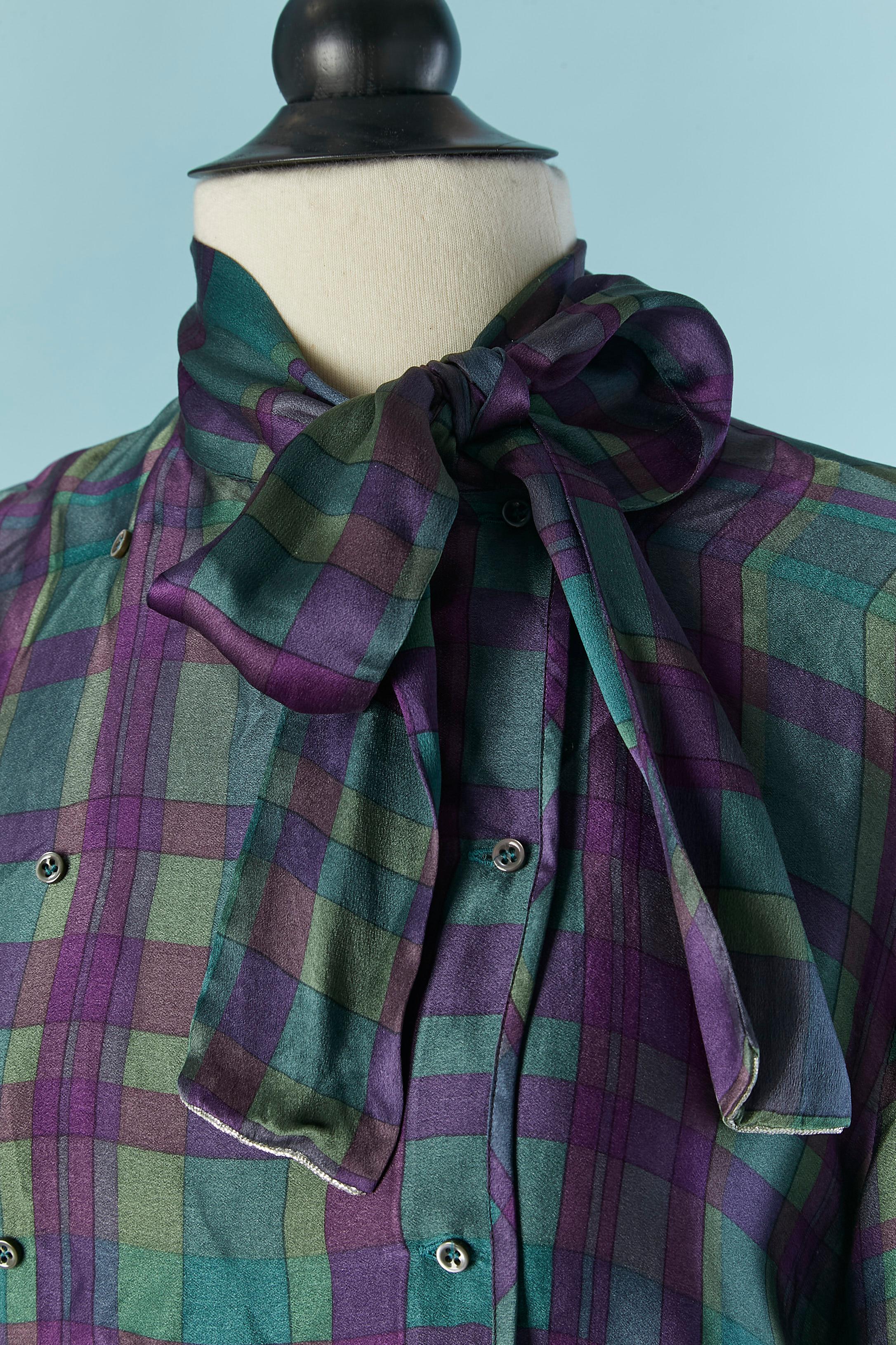 Modello a quadri Insieme di camicia e gonna in seta. Papillon sulla camicia e doppiopetto con chiusura a bottoni e asole. 
Taglia della camicia: M&M. 
Taglia della gonna: S 
