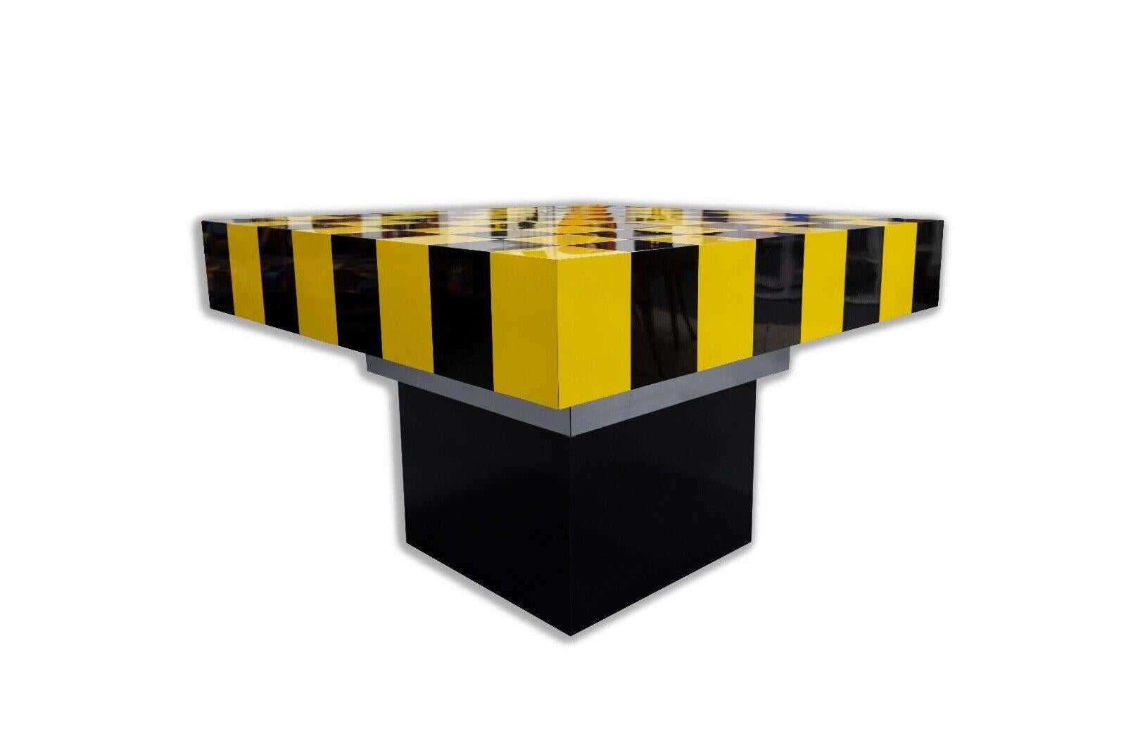 Vibrant and visually impactful, this Mid Century Modern Dining/Game Table features a checkered black and yellow tabletop. The bold pattern is reminiscent of a classic game board, suggesting versatility and fun. Its solid black base provides a sturdy