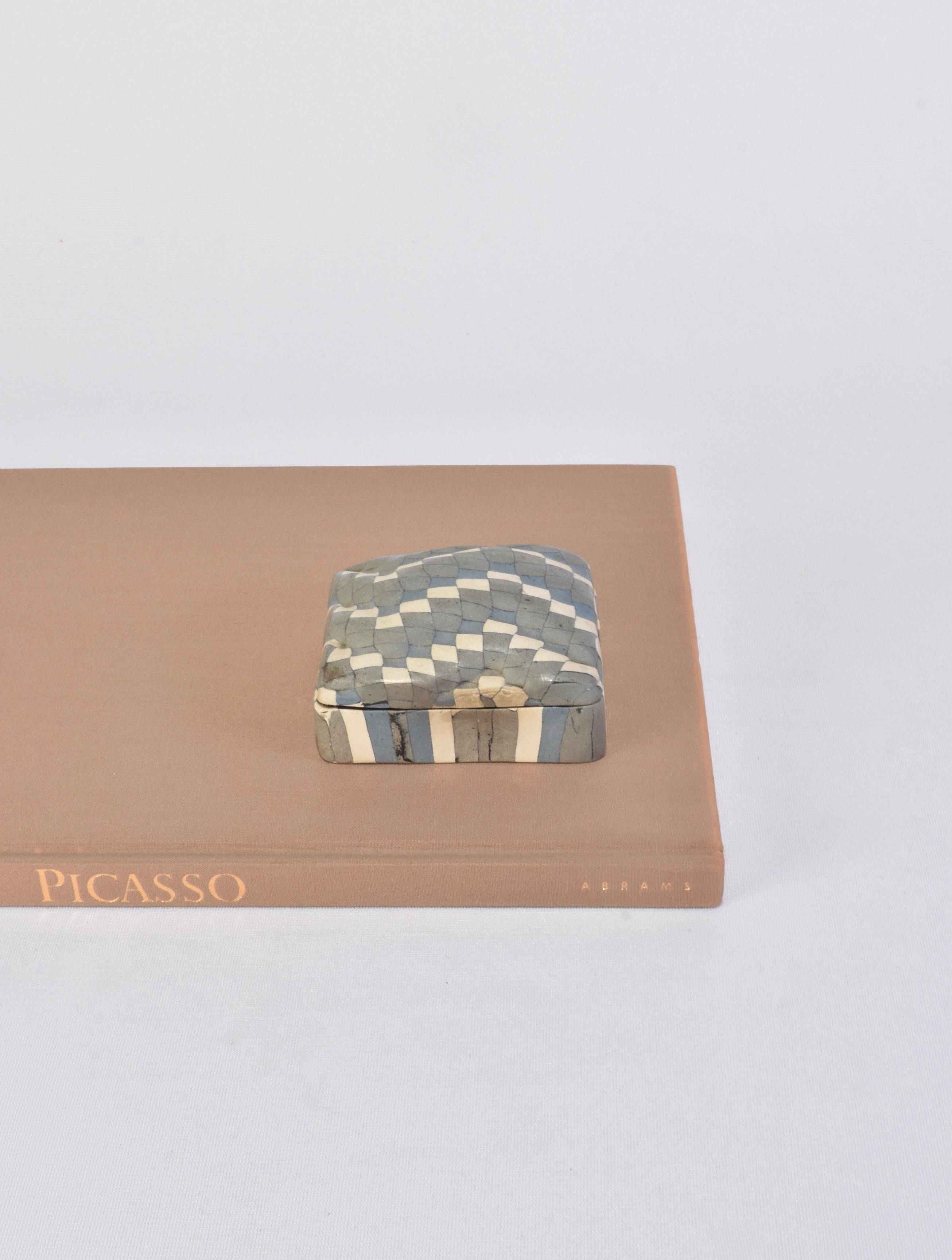 Handmade petite ceramic box in a checkered pattern with a striped base. Glazed in grey, white and blue. Signed on base.