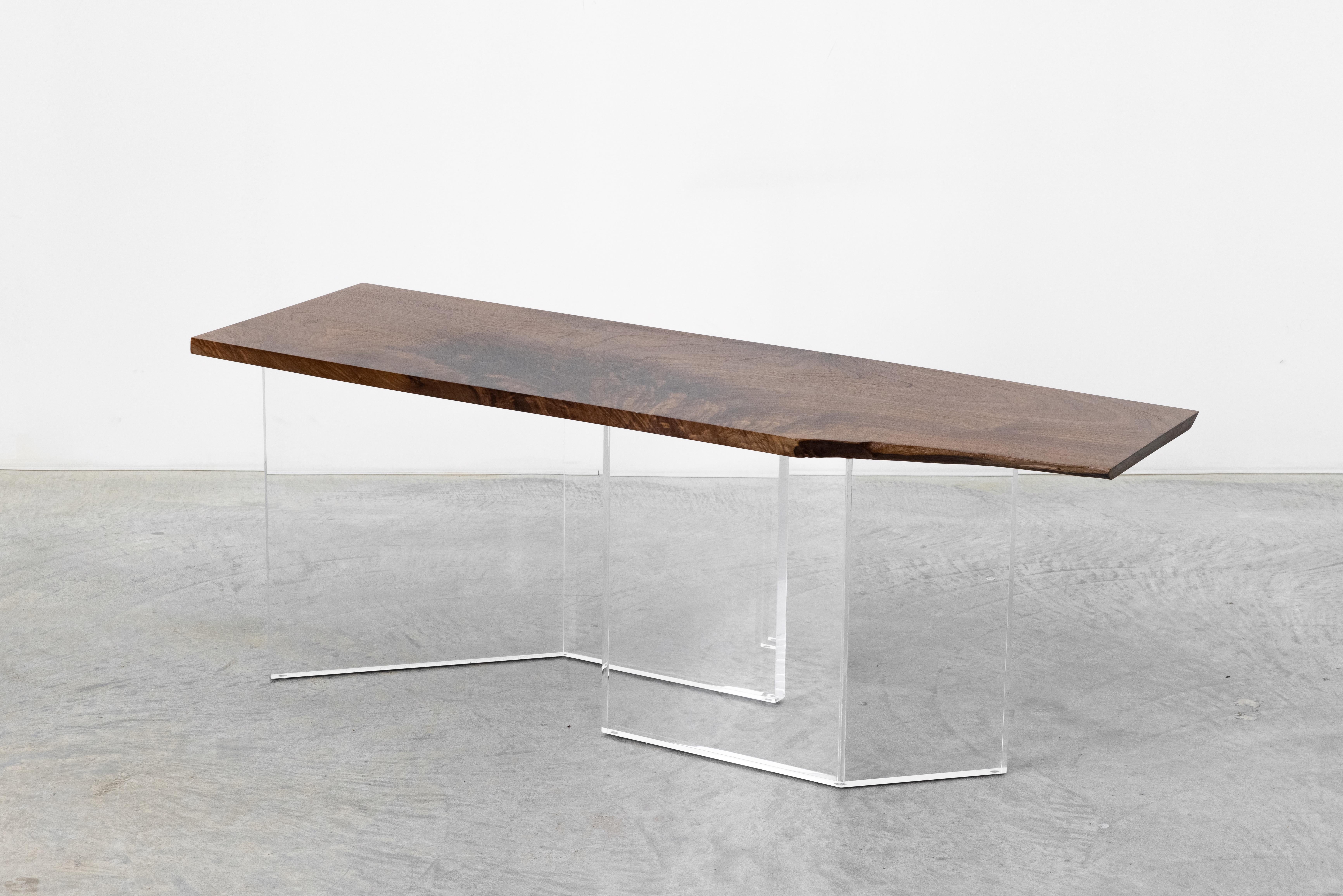 A one-of-a-kind black walnut tabletop with the most stunning natural grain set atop clear acrylic legs offset to allow light to reflect and continue the flow of energy in its space. This is a rare black walnut tabletop, with a natural edge - a