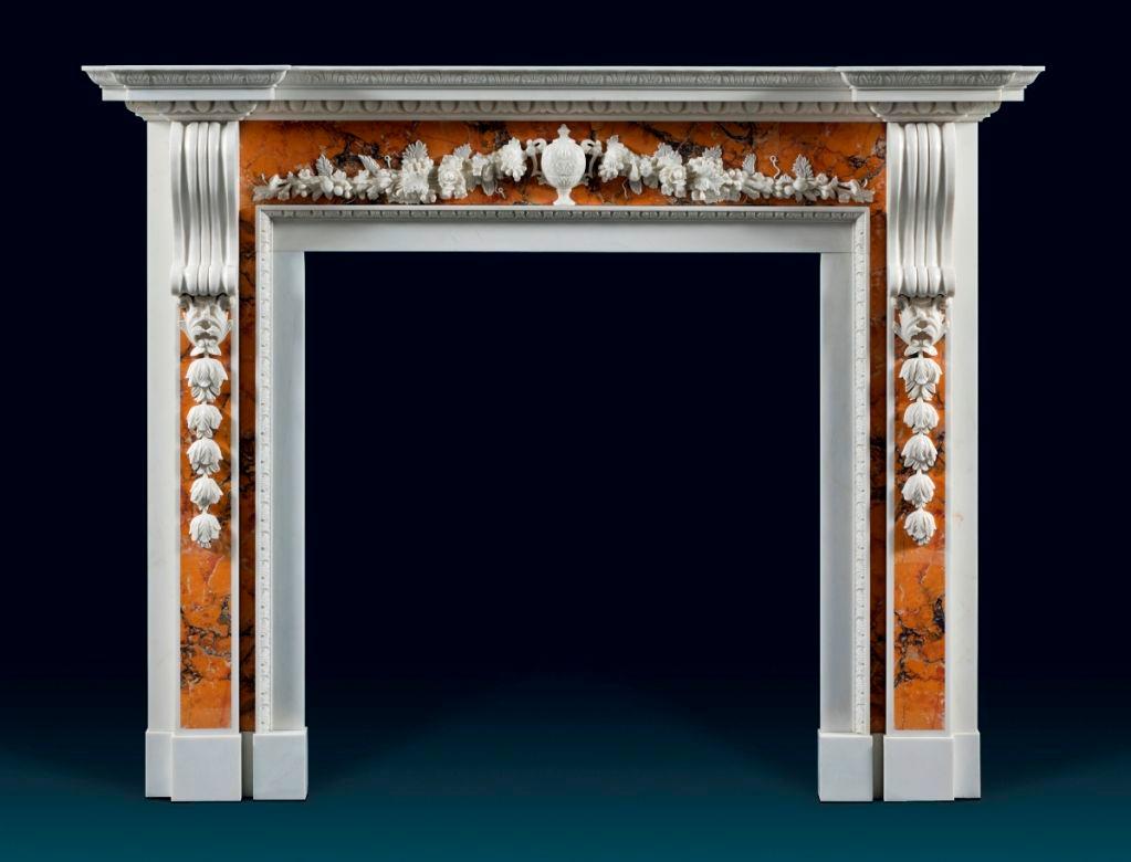 An imposing and magnificent large George II, statuary and Sienna Palladian chimneypiece. The inverted breakfront shelf is carved with acanthus leaf, egg and dart moldings. The Sienna marble frieze is centered by a classical urn, flanked by trailing