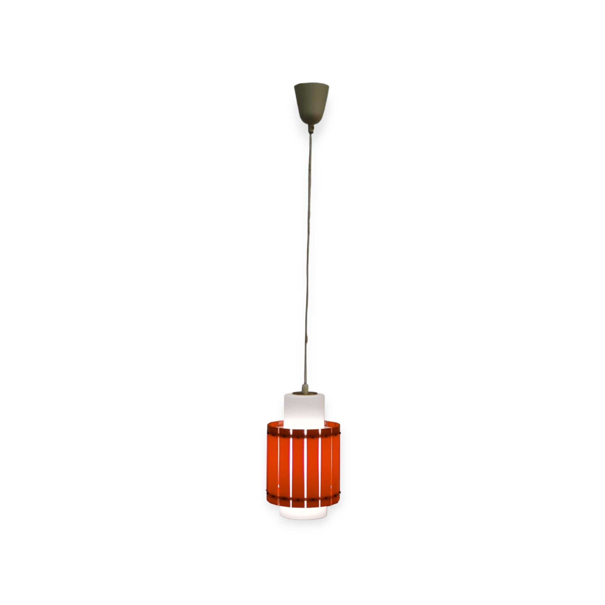A cheerful and colourful ceiling pendant by Maria Lindeman for Idman. Already designed in the late 1950s and featured in the 1961 Idman catalogue, this lamp combines a frosted glass shade with a hard plastic outer shade that makes it all more