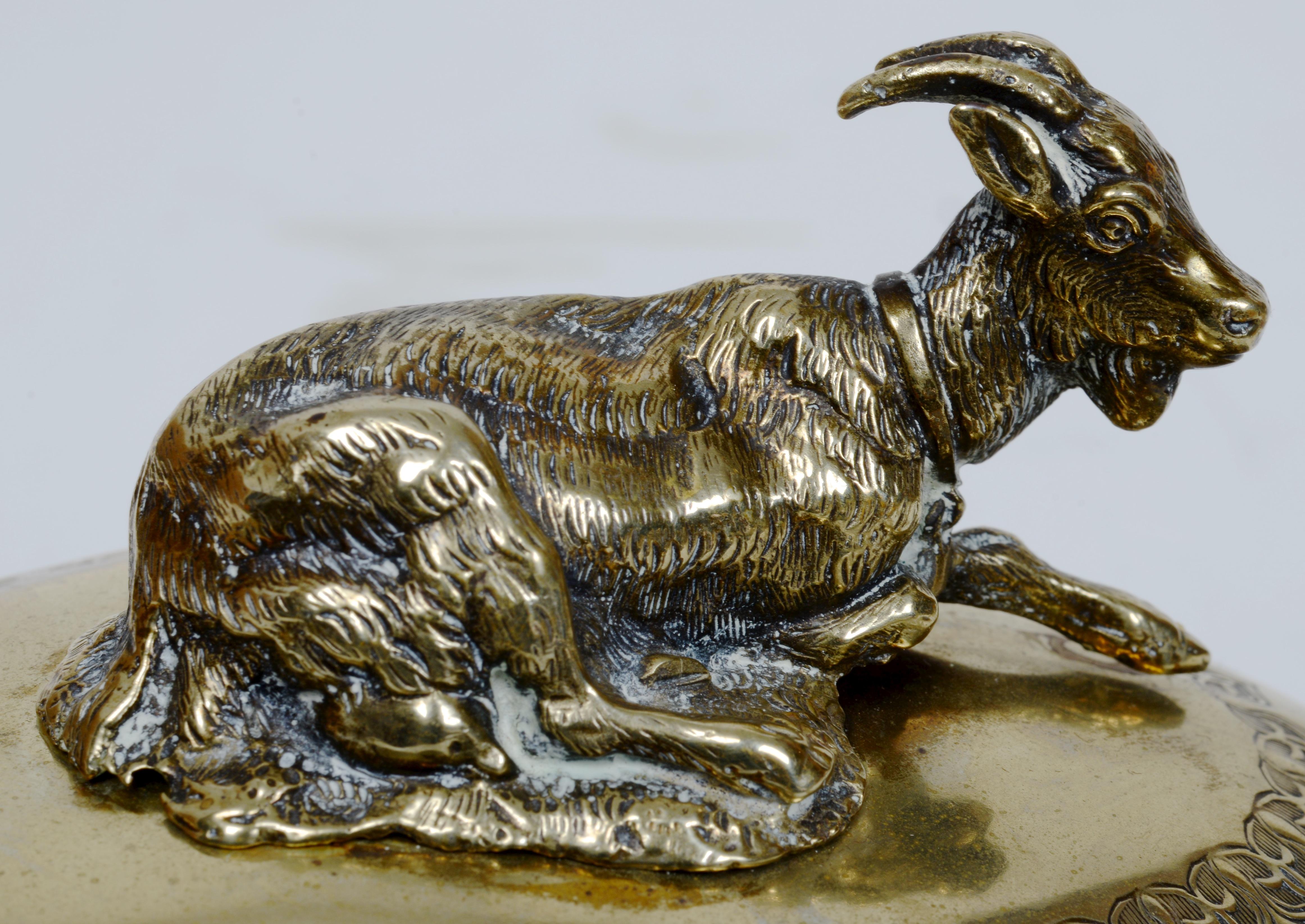 Plat à fromage ou à beurre, en laiton et verre, avec fleuron en forme de chèvre. A.I.C., probablement français et utilisé pour le beurre ou peut-être le fromage de chèvre. Le laiton est décoré d'une gravure secondaire. Le laiton porte une marque de