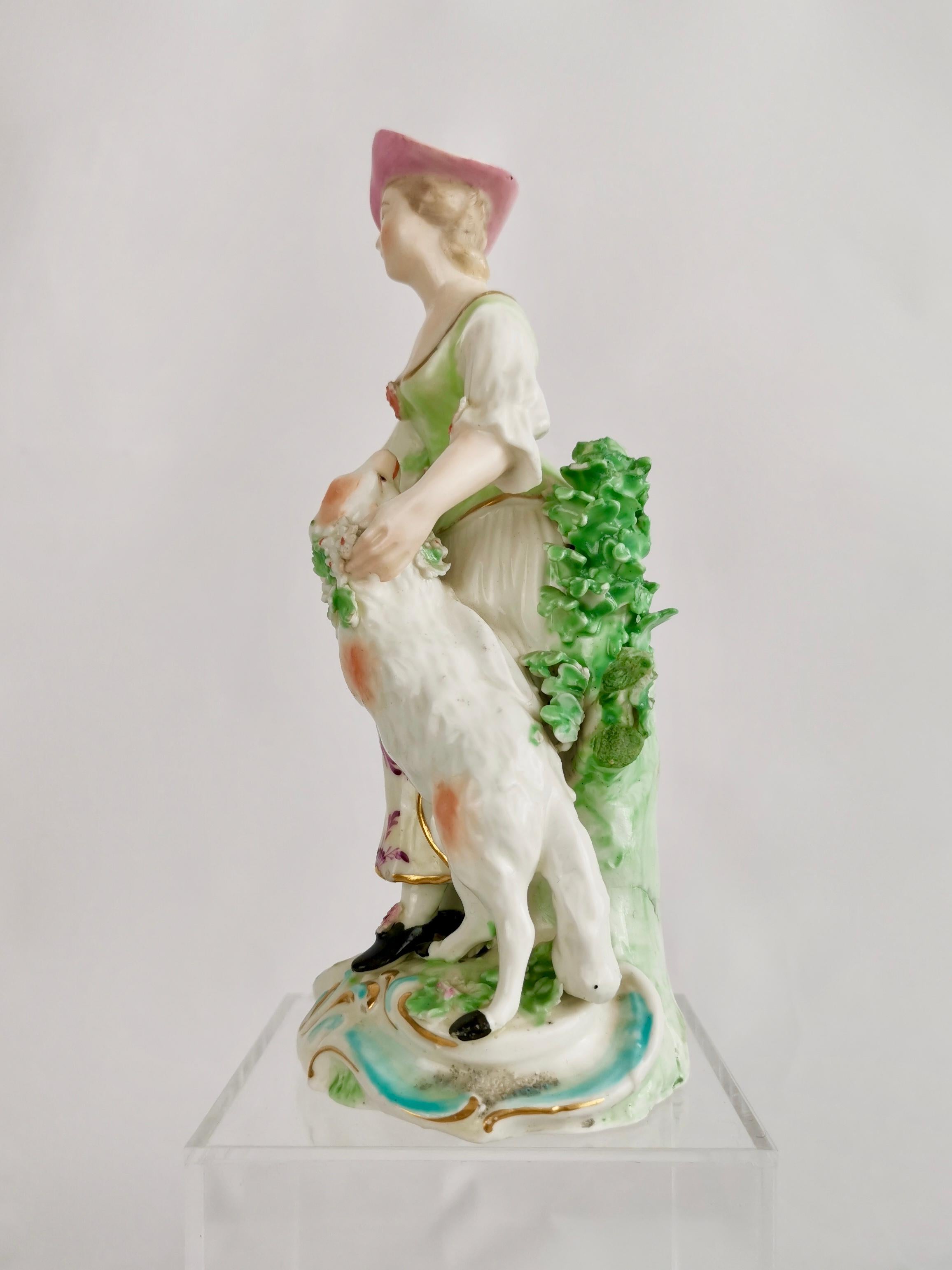 This is a charming Derby figure of a shepherdess with a garlanded lamb, made in or shortly after 1760. The figure is one half of a set called the 