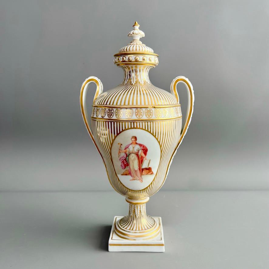 Si tratta di un vaso con coperchio molto raro e sorprendente, realizzato da Chelsea-Derby nel 1783-1784. Il vaso a forma di pera poggia su un piede quadrato e presenta due manici con catene floreali modellate e un coperchio a punta. Su un fondo a