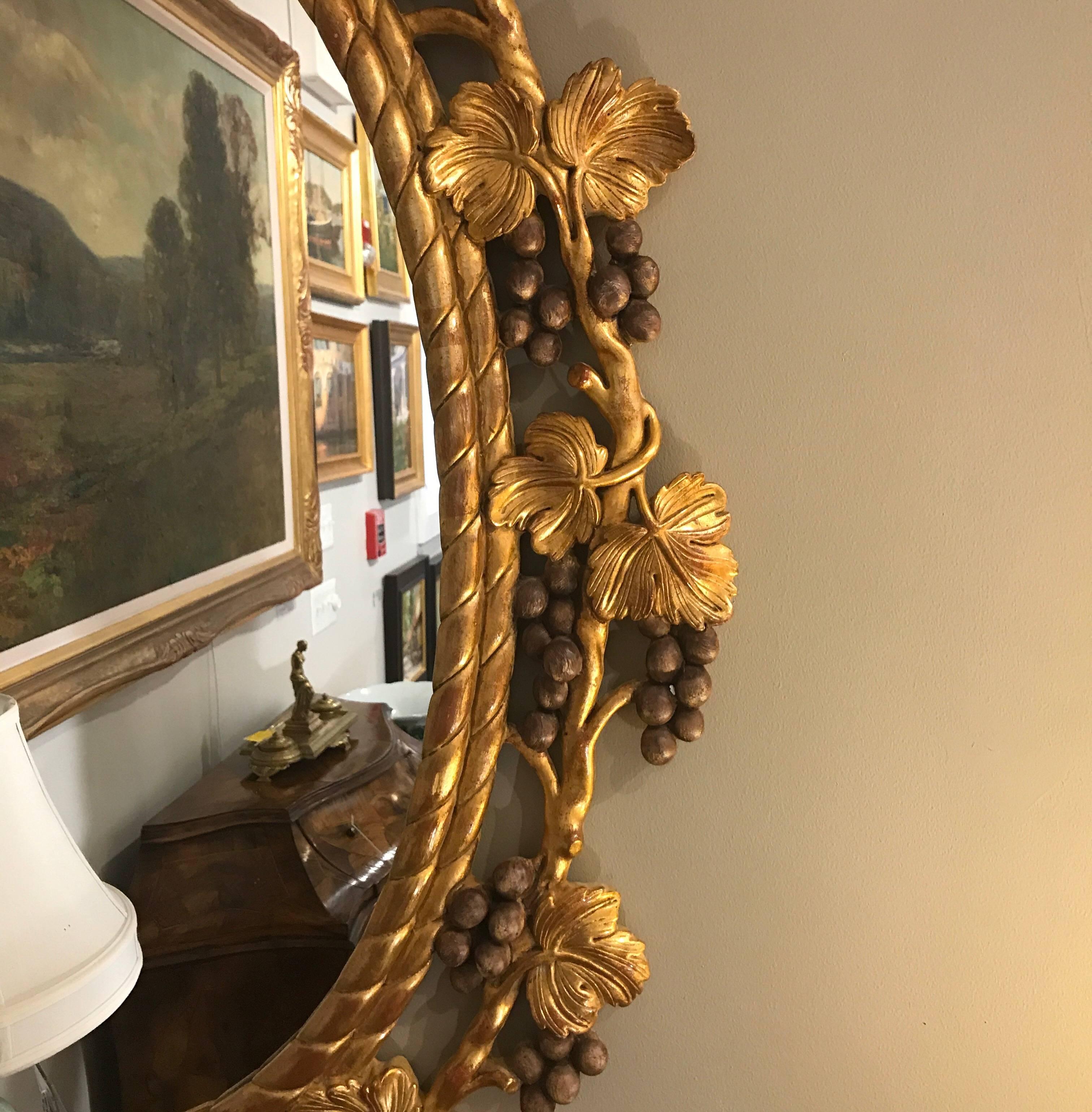 Unusual gilt wood mirror by Chelsea House. The oval frame with highly detailed grape and vine motif in an elaborate but tasteful display all around.