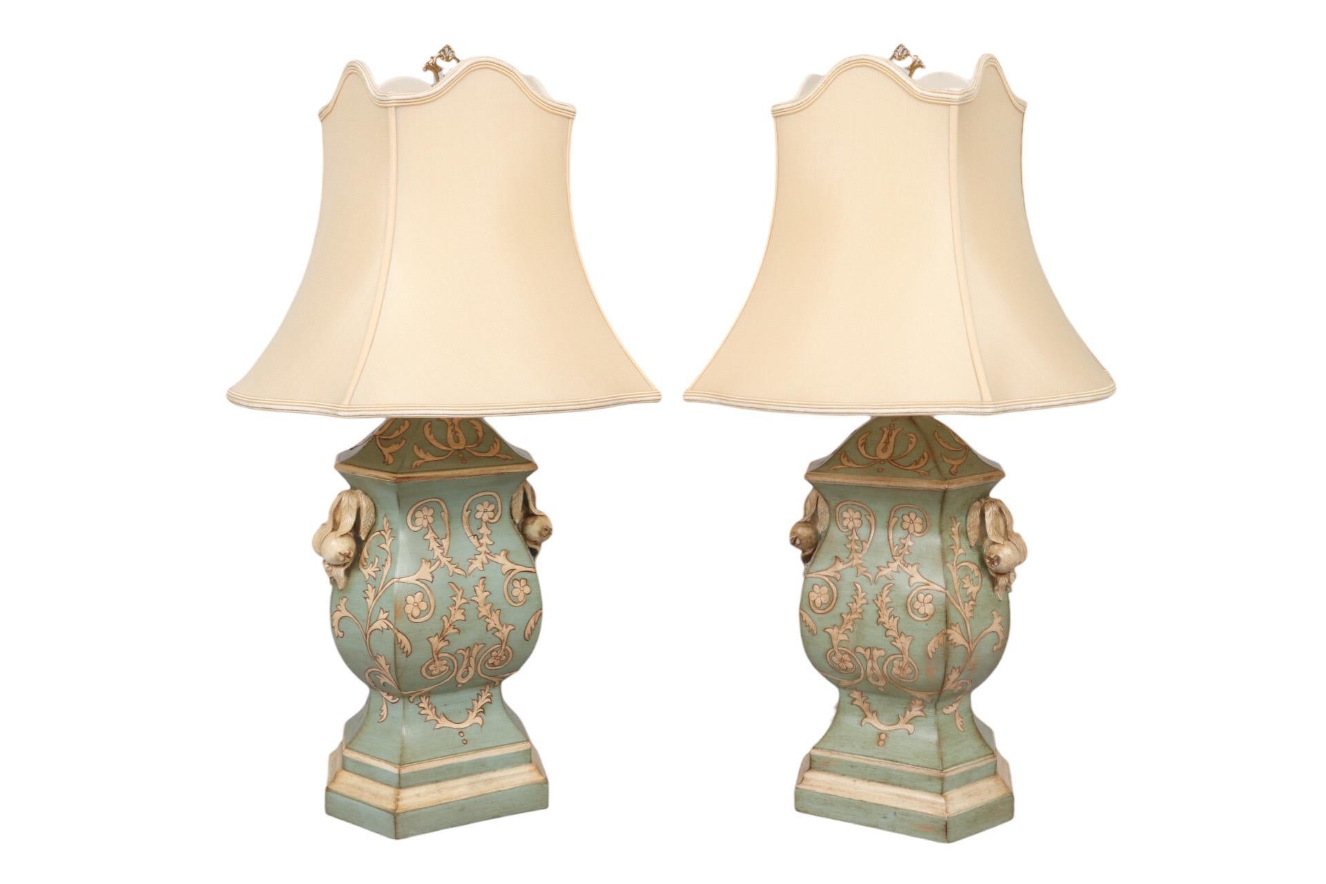 A pair of bombé hexagonal table lamps by Chelsea House. Made of resin and hand painted in a pale turquoise color, with intertwining stems of cream leaves and flowers. Each lamp is decorated on both sides with berries and leaves, has a hexagonal,