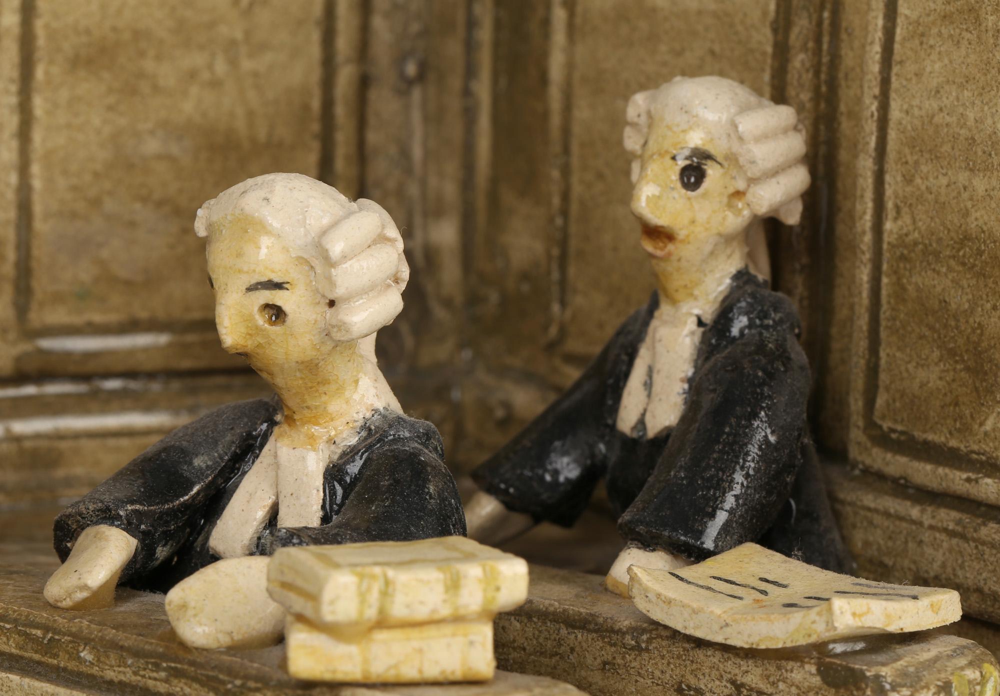 A stylish and unusual studio pottery model of a Courtroom scene by Chelsea Pottery, London and dating from the 20th century. The courtroom is modeled as a stage setting with three walls open to the front and with a judge seated at a bench with the