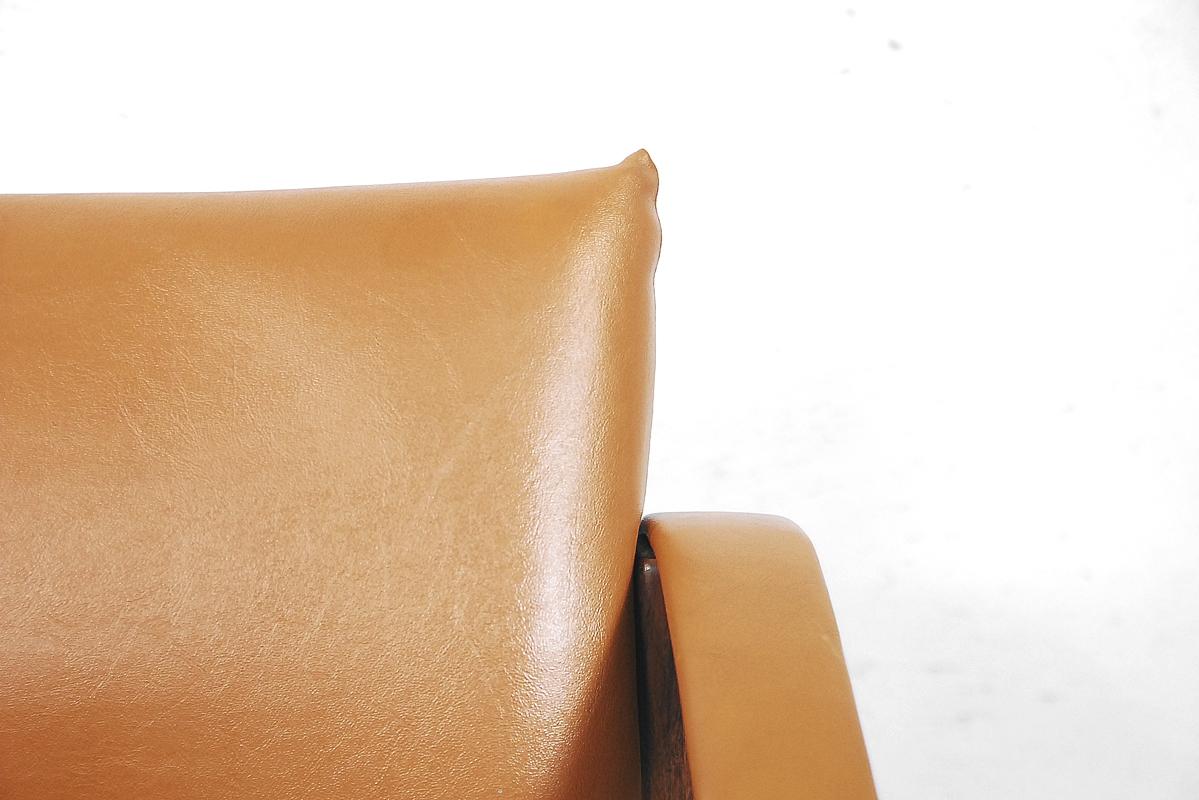 This Chelsea chair was designed by Maurice Burke and manufactured by the Arkana factory in Falkirk, Scotland, during the 1960s. It consists of a Minimalist teak frame with a comfortable leatherette seat in camel color. It is endowed in hammock