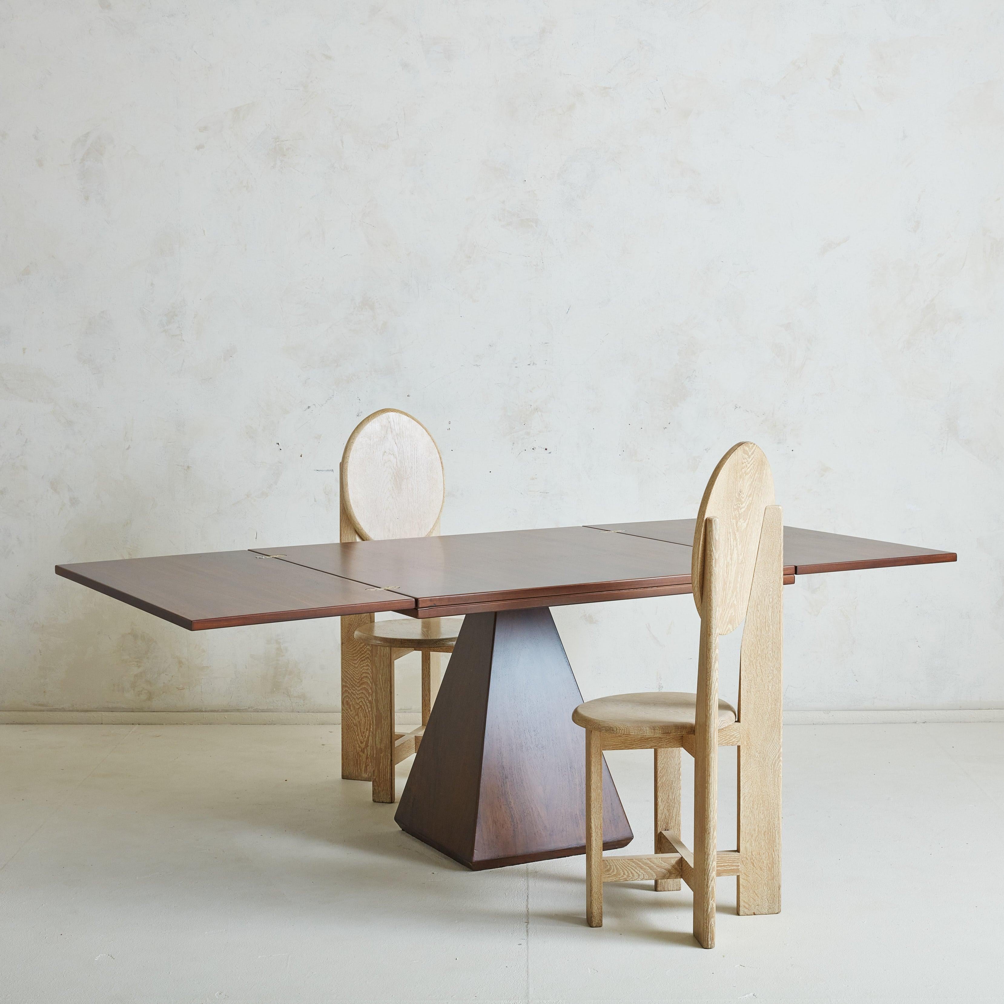 A gorgeous 'Chelsea' extendable dining table by Italian architect Vittorio Introini for Saporiti in the 1960s. This dining table is composed of beautifully grained solid rosewood in a rich, dark brown hue and features a pyramid-form pedestal base.