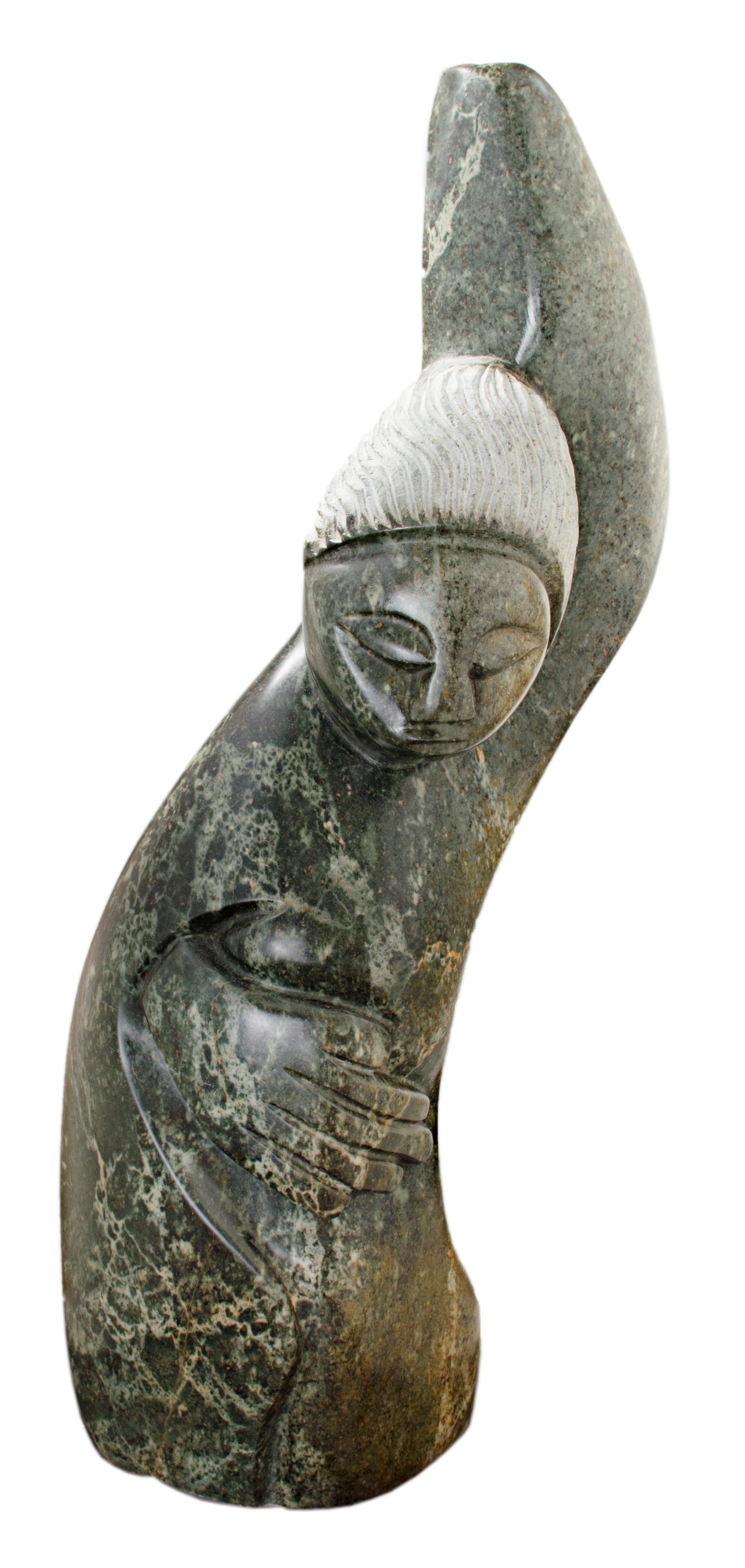 "Mi querido amigo" es una piedra verde de serpentina firmada por Chemedu Jemali, que es un shona africano. El cuerpo de la figura tiene una forma fluida, con la mano izquierda en el cielo y la derecha enrollada alrededor del vientre. La figura está