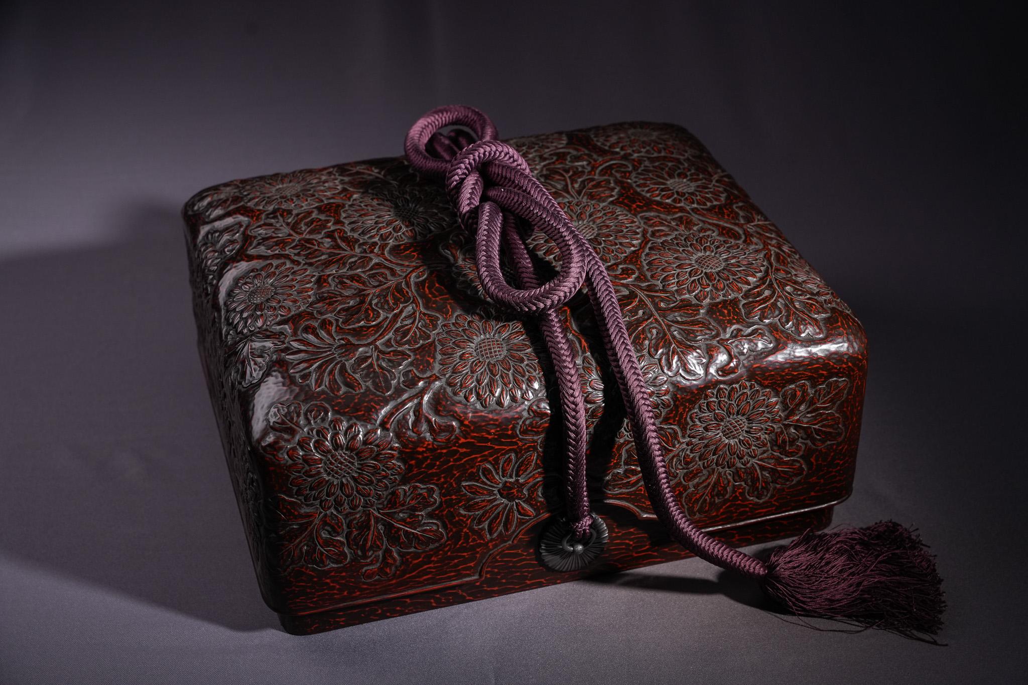 Diese große Chrysanthemen-Lackdose von Chen Wu ist ein Beispiel für Kamakura-bori-Lackwaren aus der Edo-Periode. Er ist auf einem massiven Holzkern aufgebaut, mit dunklen Lackschichten überzogen und tief mit blühenden Chrysanthemenmotiven
