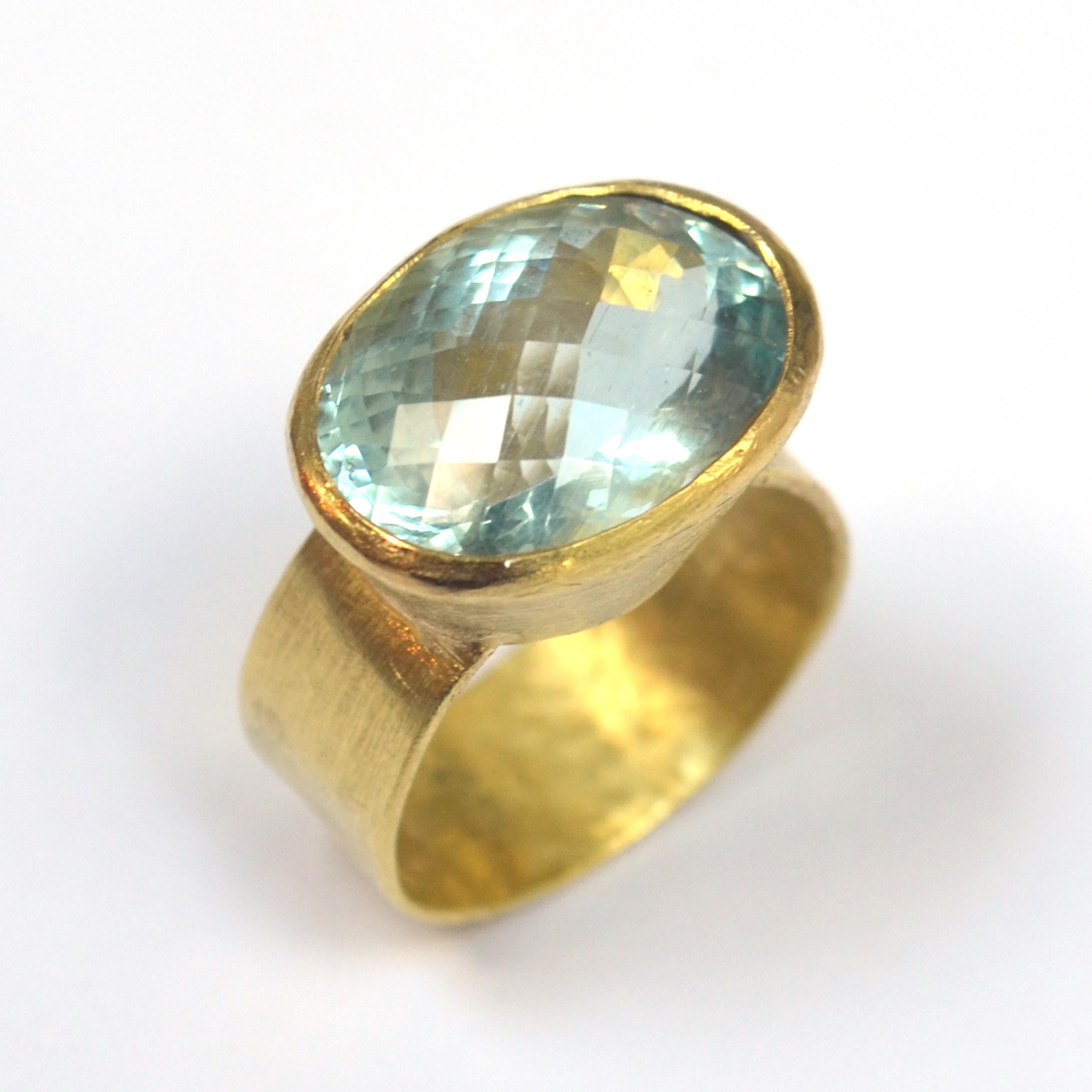 8ct oval Aquamarine with 'chequerboard' cut surface wide hammered texture 18k Gold ring.

This ring is handmade by Disa Allsopp in her London Studio. Disa is inspired by ancient cultures to create contemporary jewellery using traditional