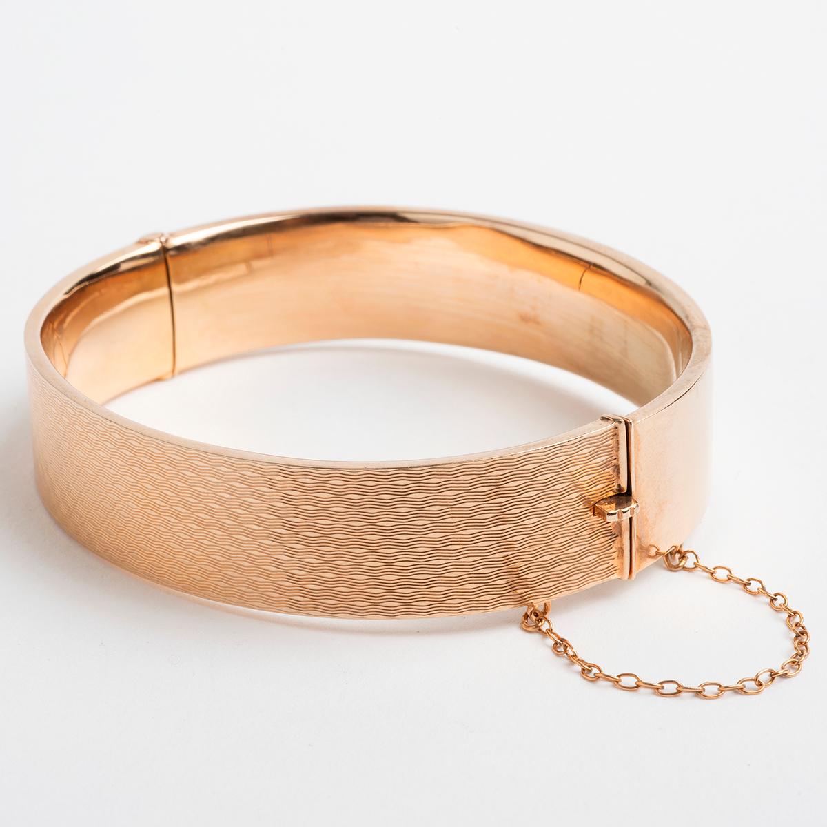 Our rare vintage 9k rose gold wide hinged hollow bangle features a beautiful chequered design, and is secured by a box and tongue clasp with safety chain. Hallmarked Birmingham, U.K., 1939 and SB&S Ltd. The diameter is 5.8cm, weight 13.9g. A pretty