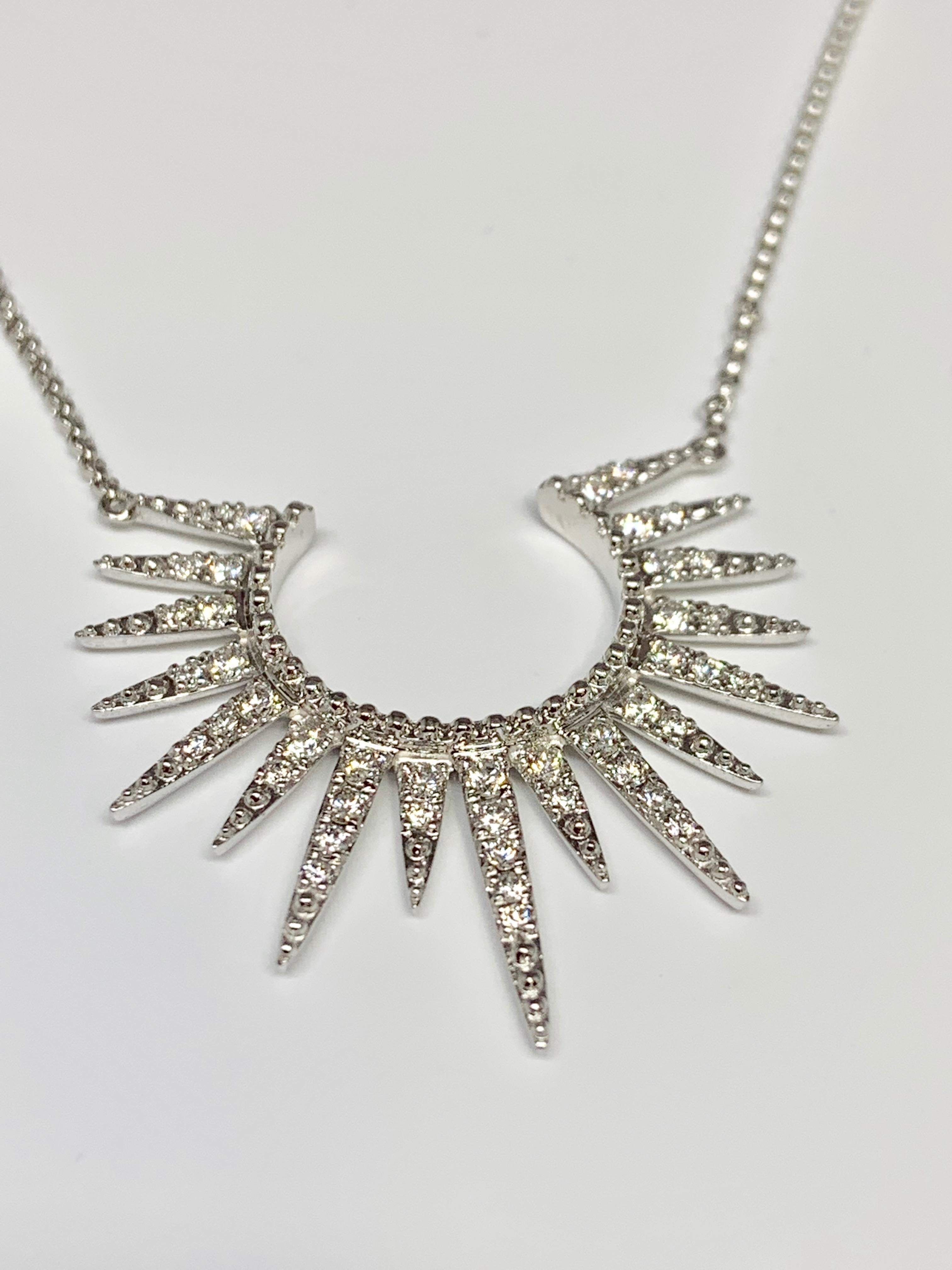 This starburst-style diamond necklace from Cherie Dori features 0.55 carats of round white diamonds set in 14K white gold. The pendant is attached to a 14K white gold rolo chain that is adjustable and can be worn as an 18 inch, 17 inch, or 16 inch