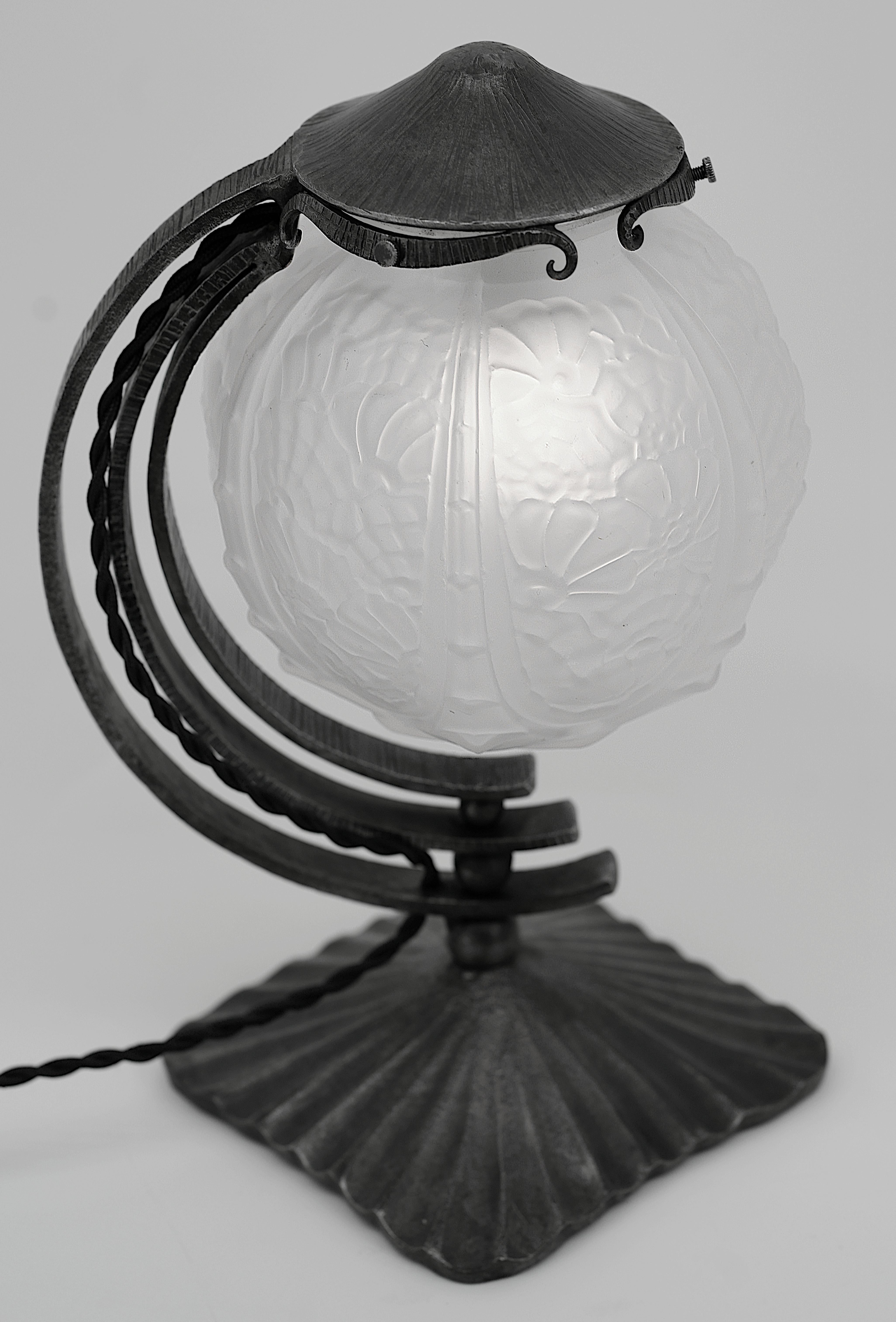 French Art Deco table lamp by CHERRIER & BESNUS, 36, rue Amelot, Paris, France, ca.1925. Glass & wrought-iron. Molded glass shade showing a stylized floral pattern hung on its stunning wrought-iron fixture. Height : 28.5cm (11.2