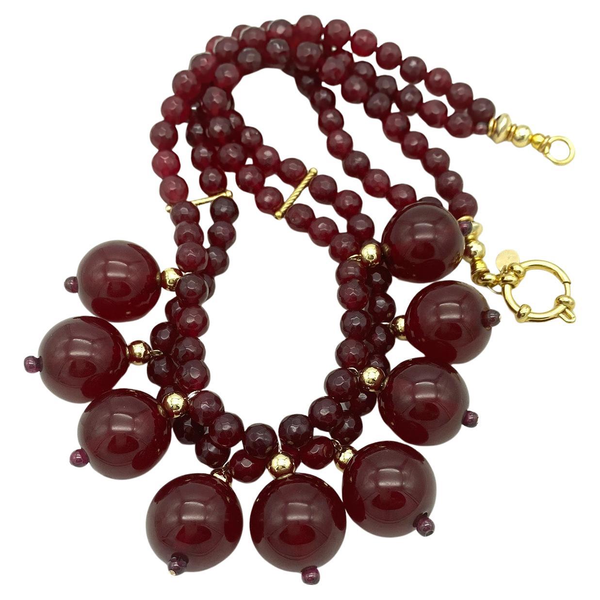 Abbiamo creato questa collana a doppio filo con nove charme grandi da 19 mm in bachelite color ciliegia collegati ai due fili di granato sfaccettato da 8 mm. Questa collana è completata da una chiusura ad anello a molla in oro 24K e da altri