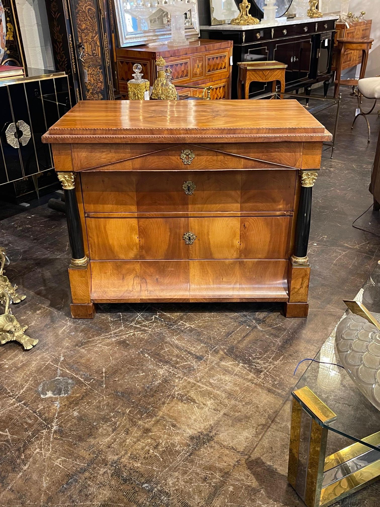 Handsome 19th century German Empire Biedermeier cherry commode with ebonized columns, Circa 1840. This piece has beautiful wood grain and polish. Sure to make a statement.